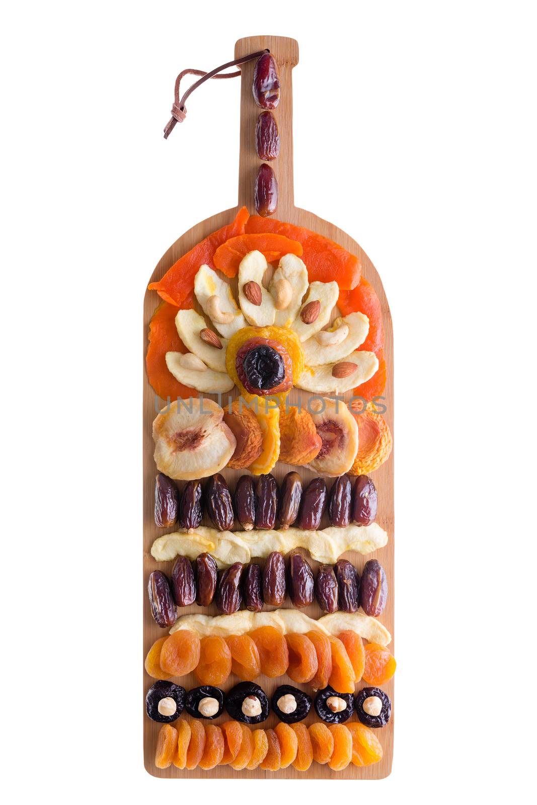 Decorative creative arrangement of colorful dried fruit and nuts displayed on a wine bottle shaped bamboo cutting board viewed form above isolated on white