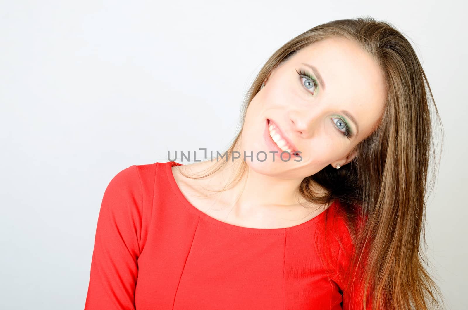 Portrait of young female model. Kind girl with smiling face. Model wearing red dress.  