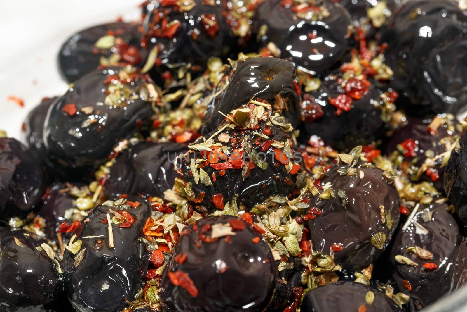 Close up detailed view of black olive with spices on.