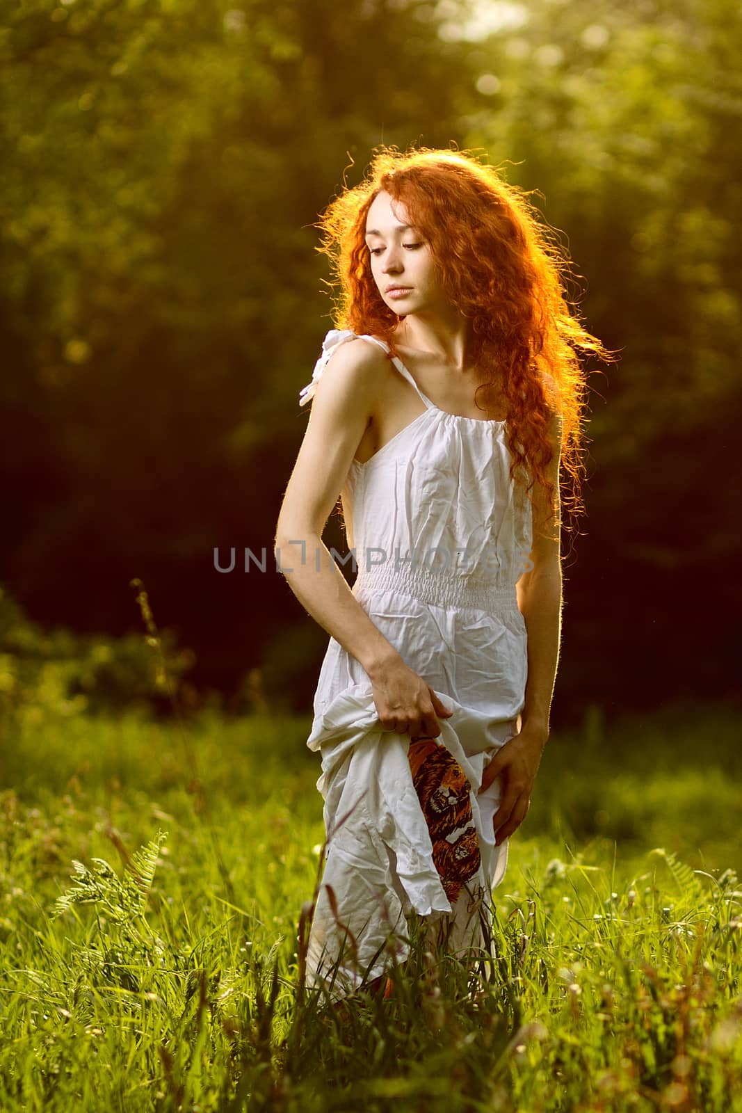 Redhead girl walking under rays of sunset forest by mrakor