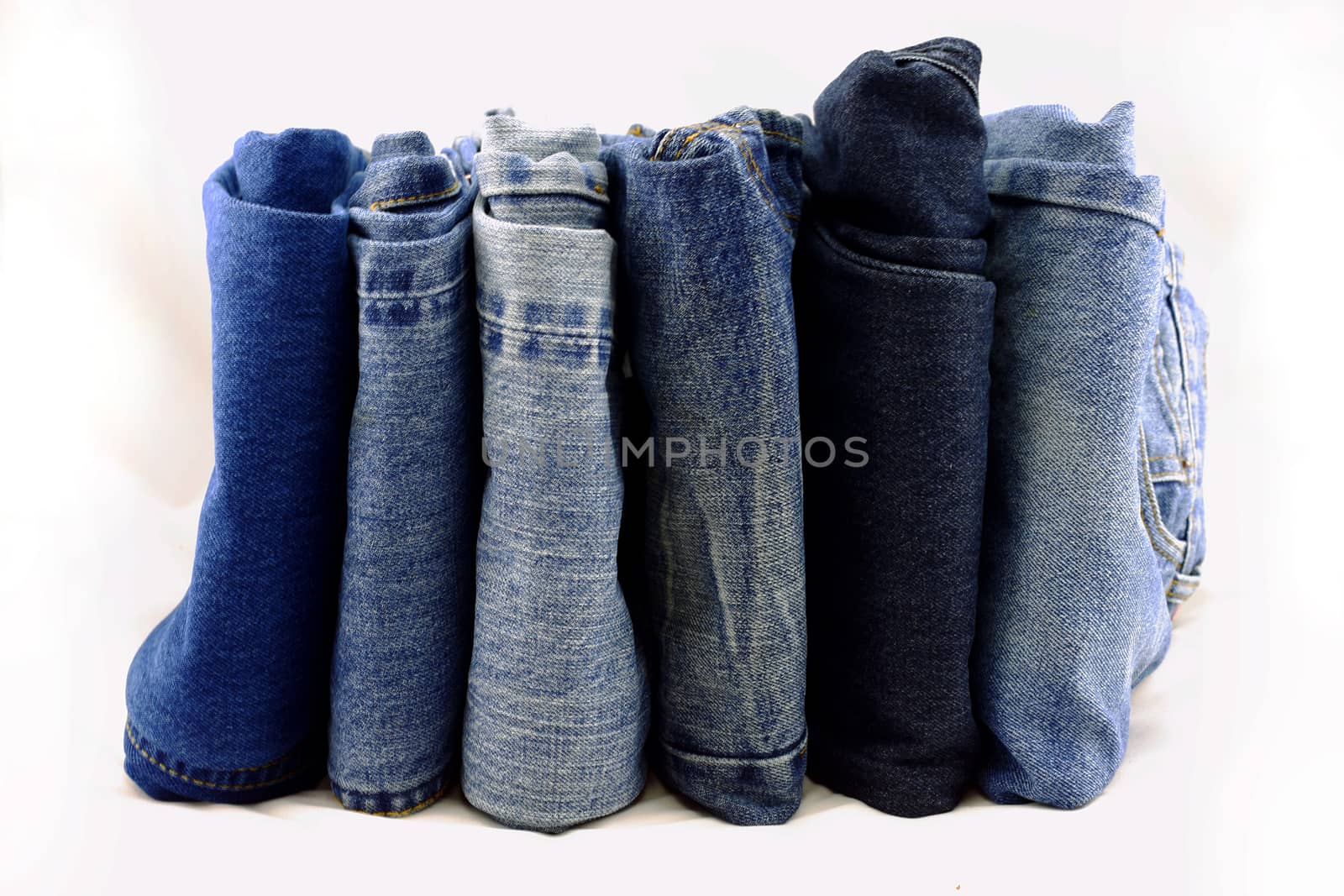 Blue jeans pants pile on a white background.