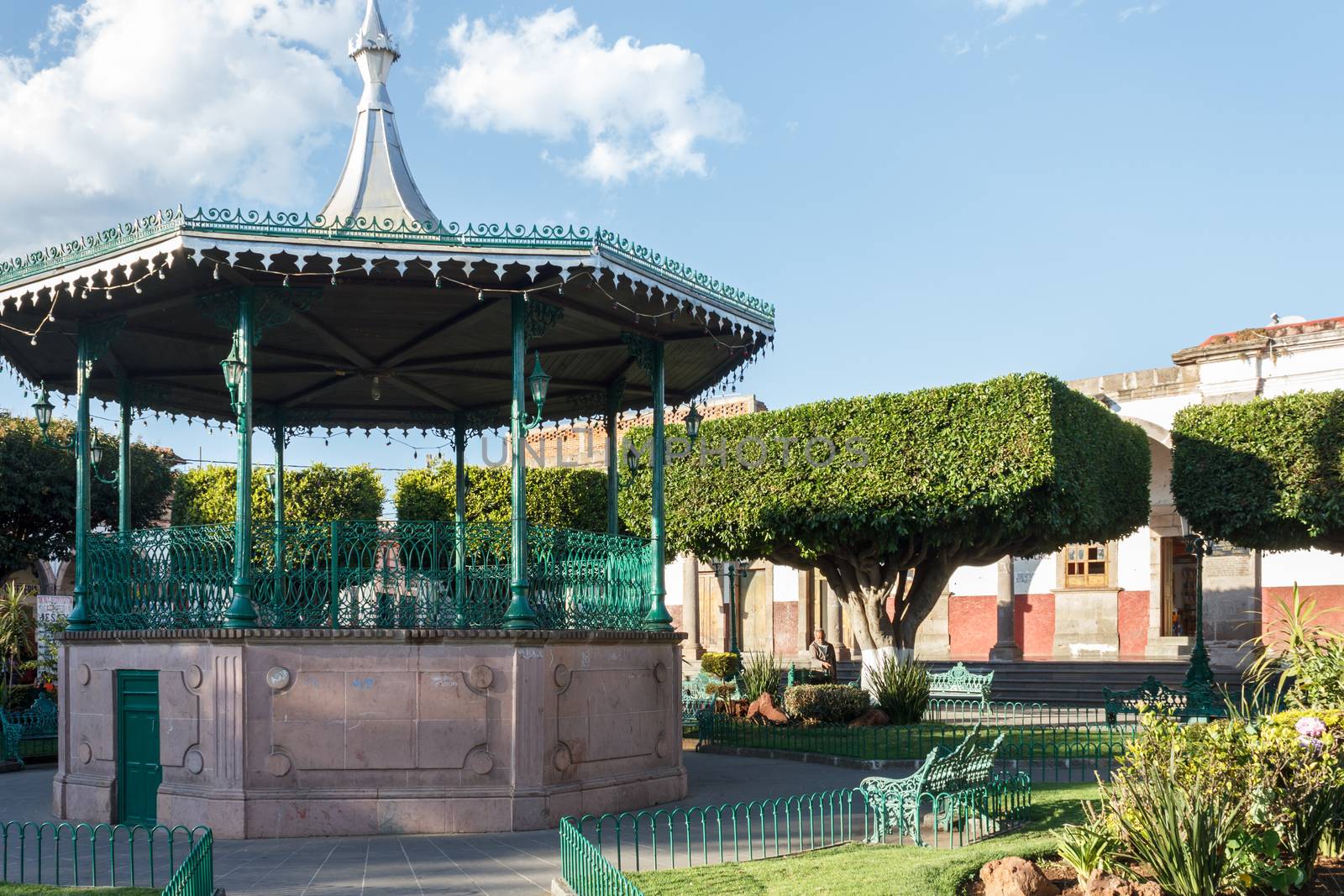 A gazebo at a plaza with  trees cut into square shapes in Quiroga, Michoacan, Mexico