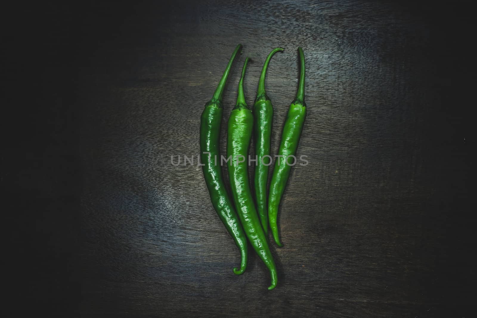 Close up hot peppers spices on black wooden table.