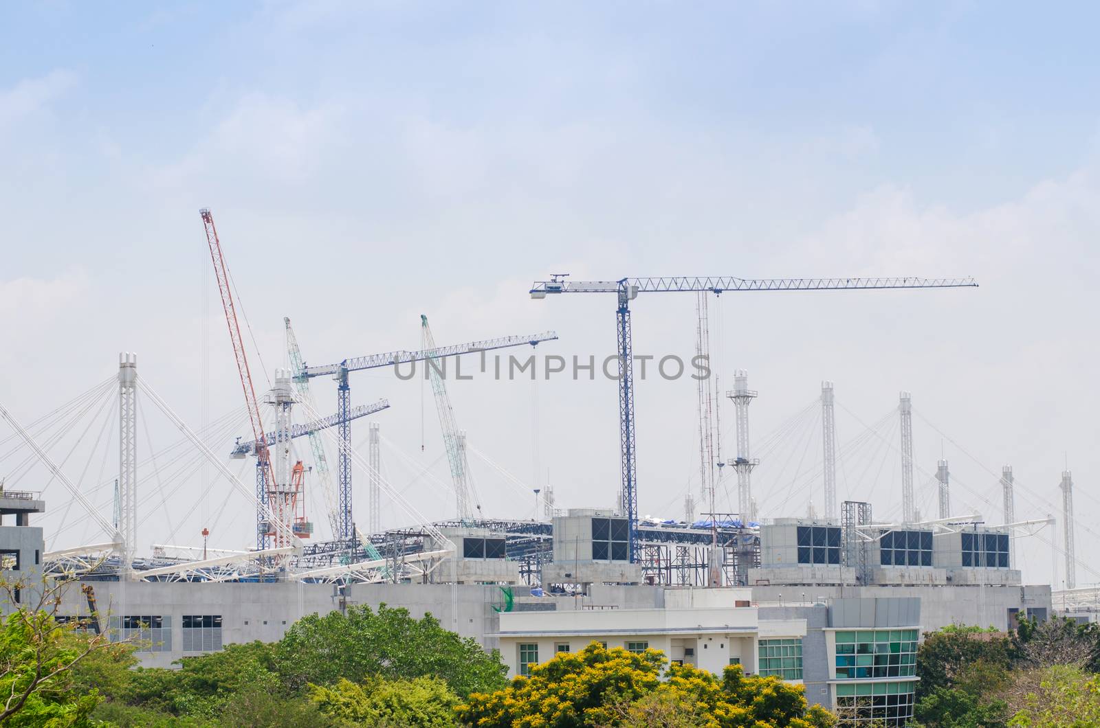 Mega construction site and cranes against blue sky