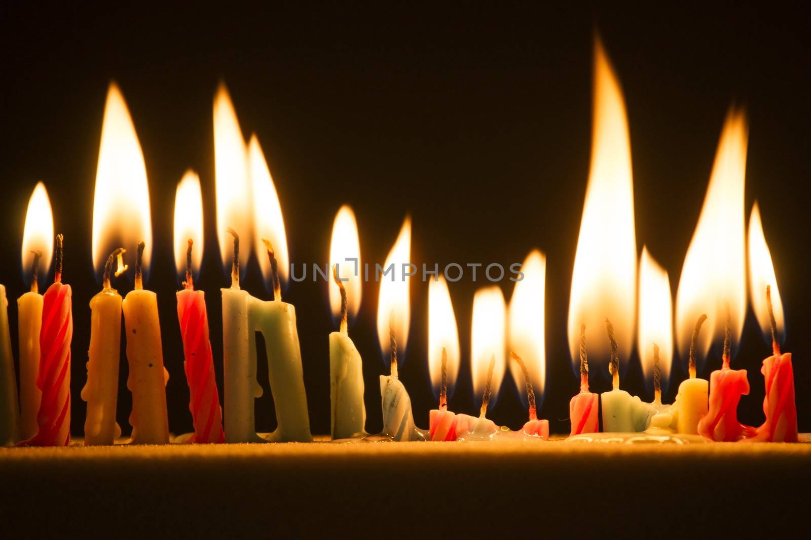 Series of small lighted candles on a black background