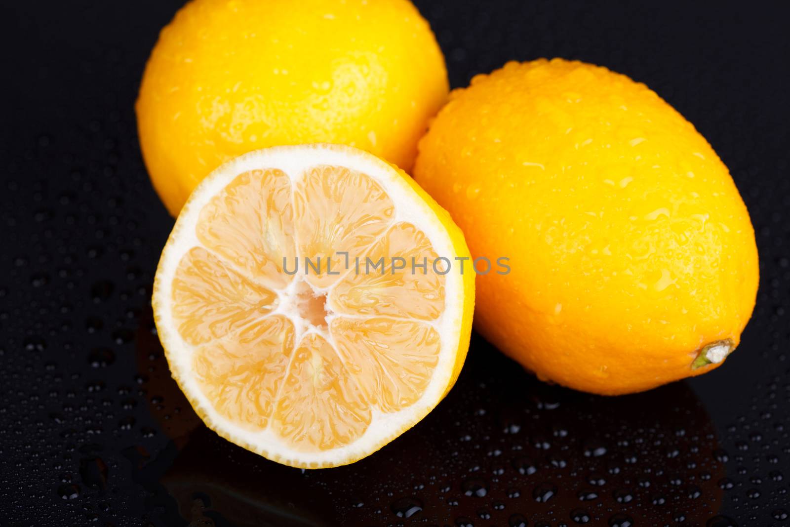 Juicy delicious lemons on wet table