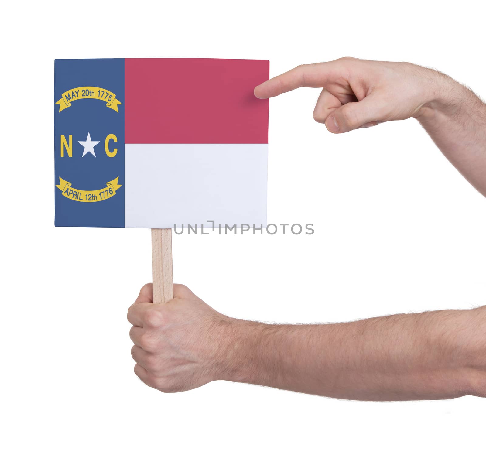 Hand holding small card, isolated on white - Flag of North Carolina