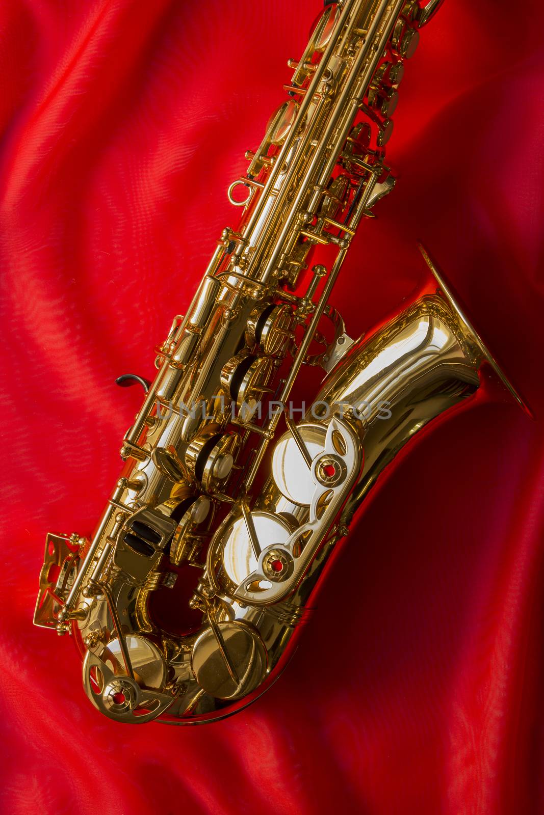 beautiful golden saxophone on delicate red silk background