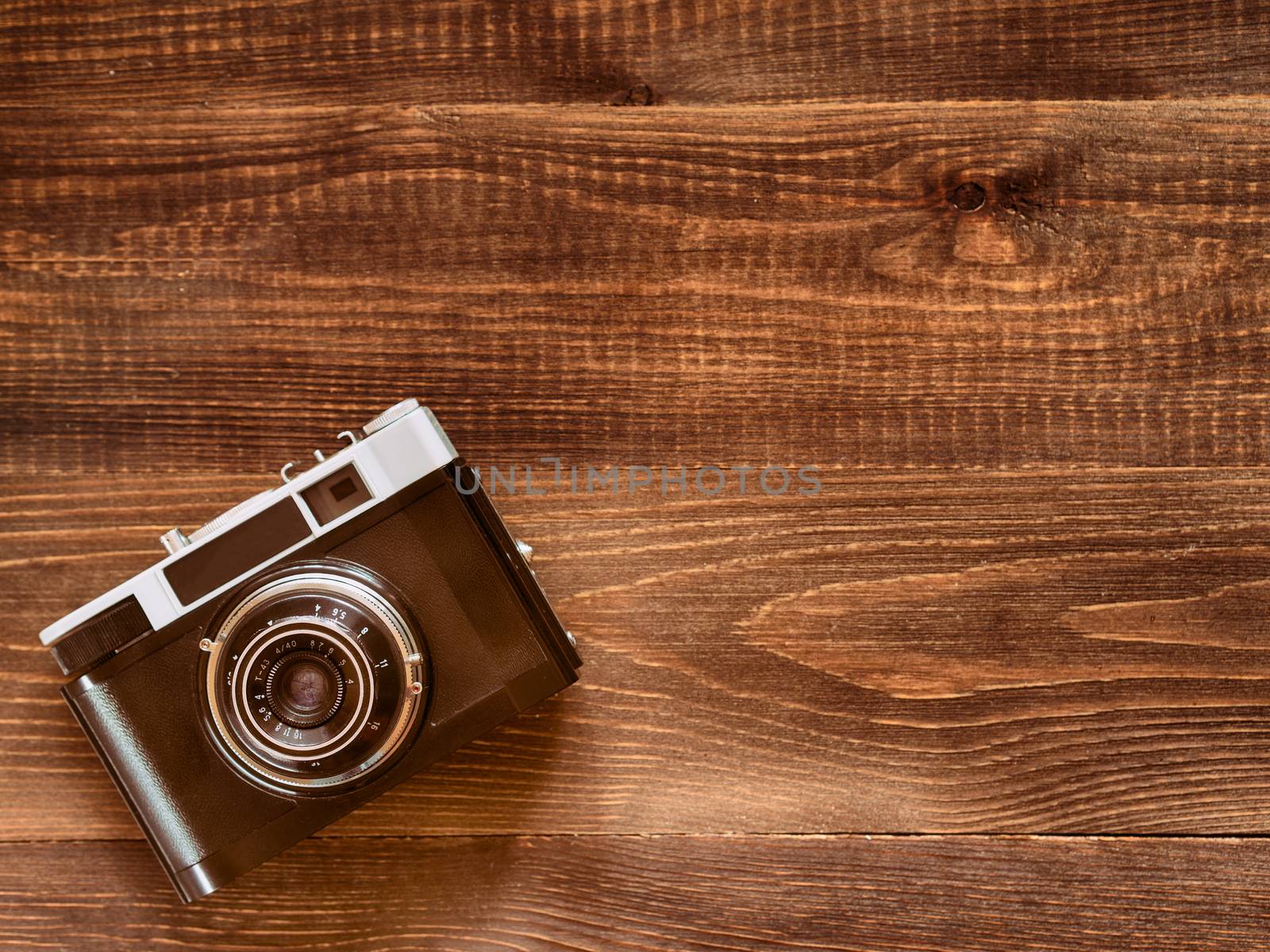 top view image of vintage old camera on wooden table background. Flat lay