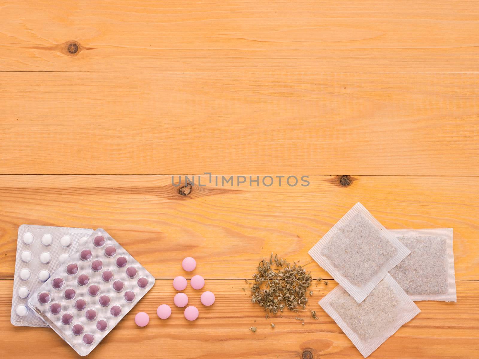 Herbal medicine and Chemical medicine the alternative healthy care on a light wooden background with copy space. Flat lay or top view