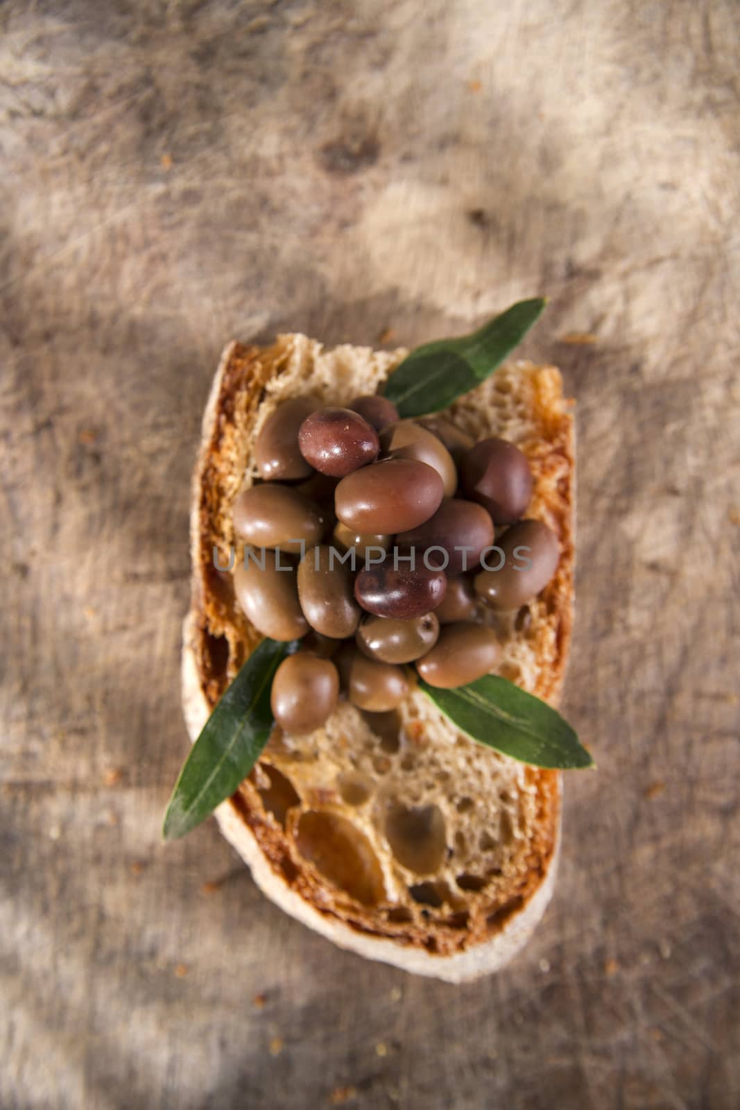 Snack of slice of bread with olives in brine