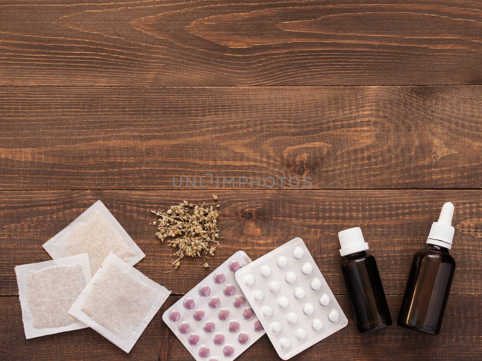 tablets, drops and herbals on a dark wooden background by fascinadora