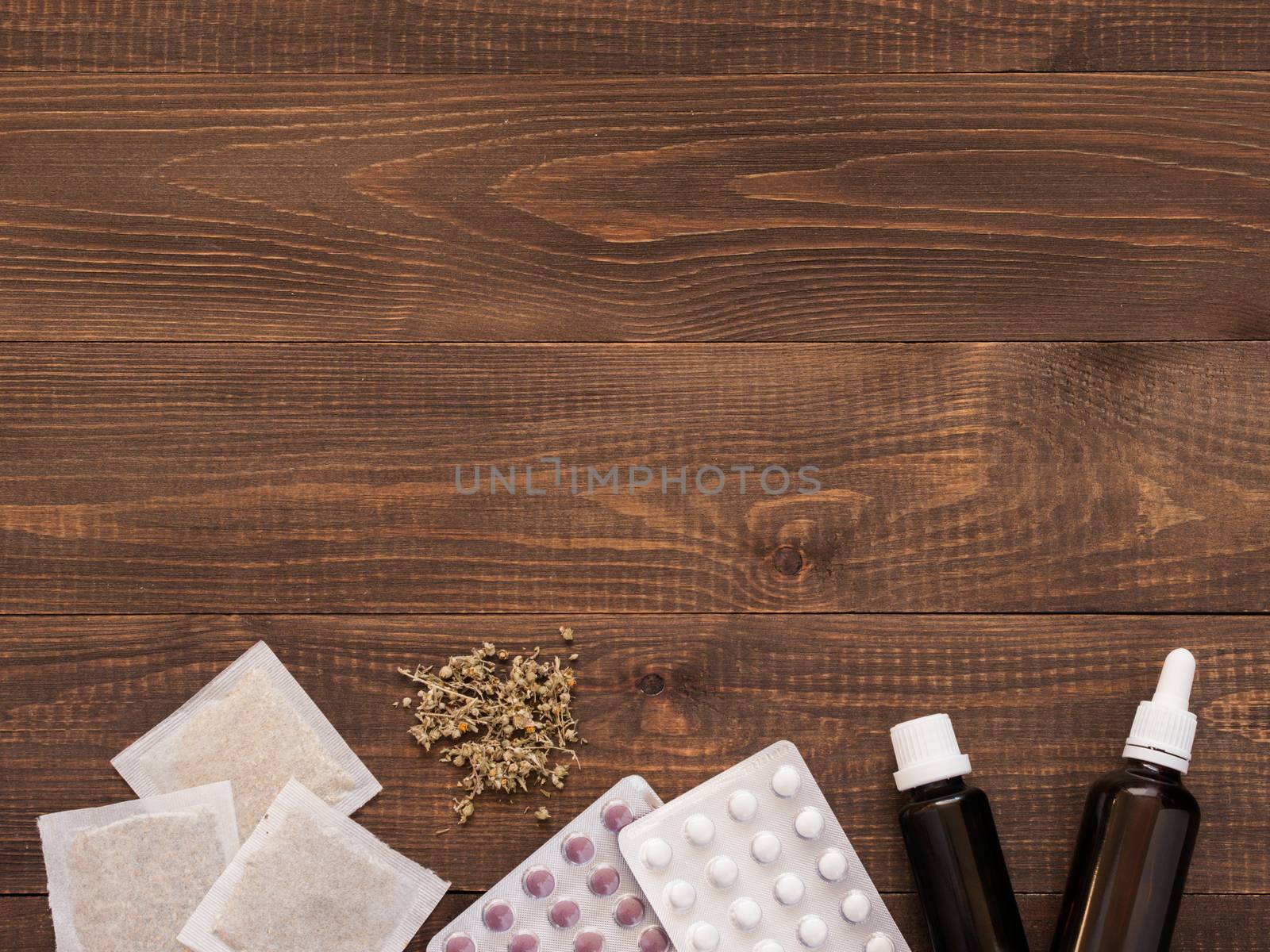 tablets, drops and herbals on a dark wooden background with copy space. Flat lay or top view