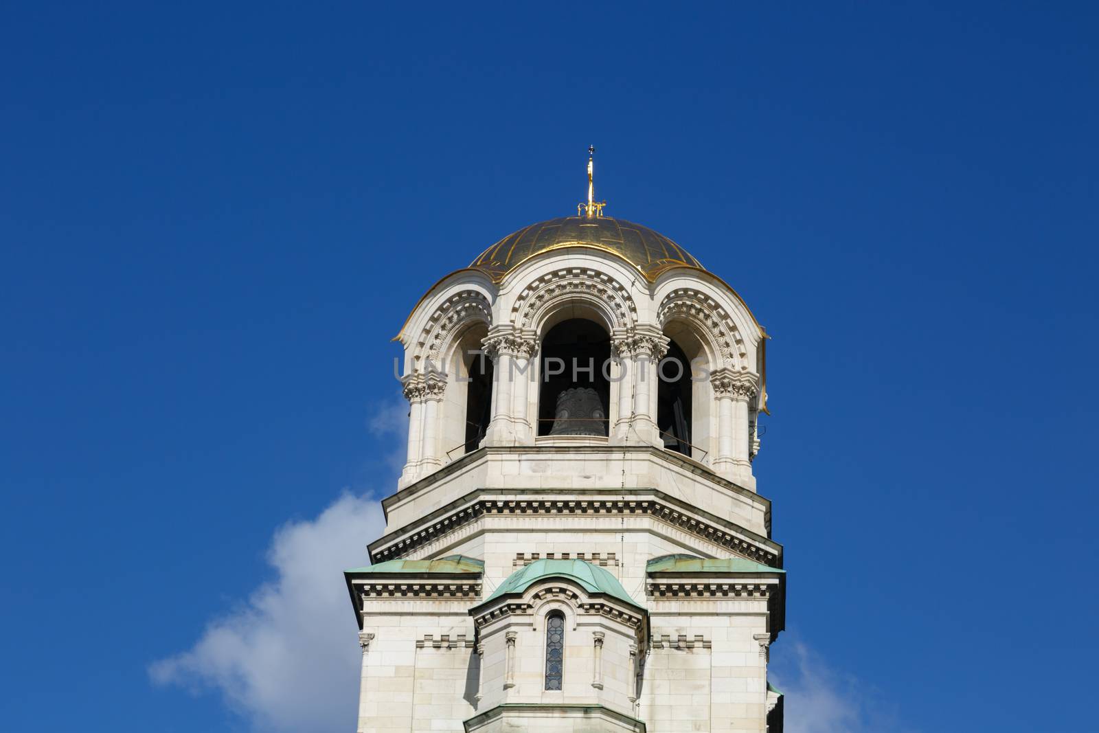 Close up detailed bellfry tower view of famous Bulgarian Orthodox church of Alexander Nevsky Cathedral built in 1882 in Sofia, Bulgaria, on blue sky background.