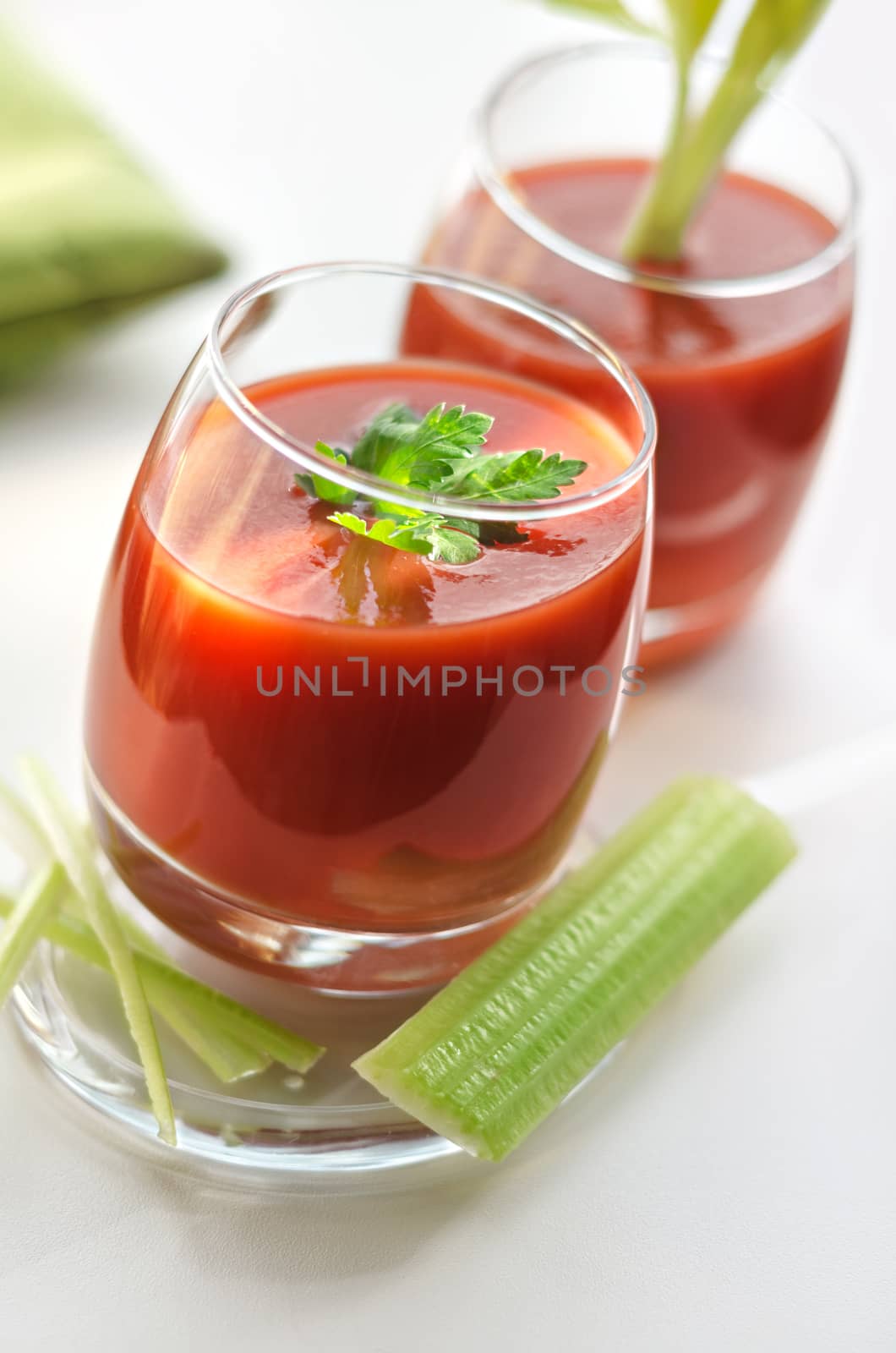 Two glasses of tomato juice and slices of celery, morning, bokeh. Defocused background