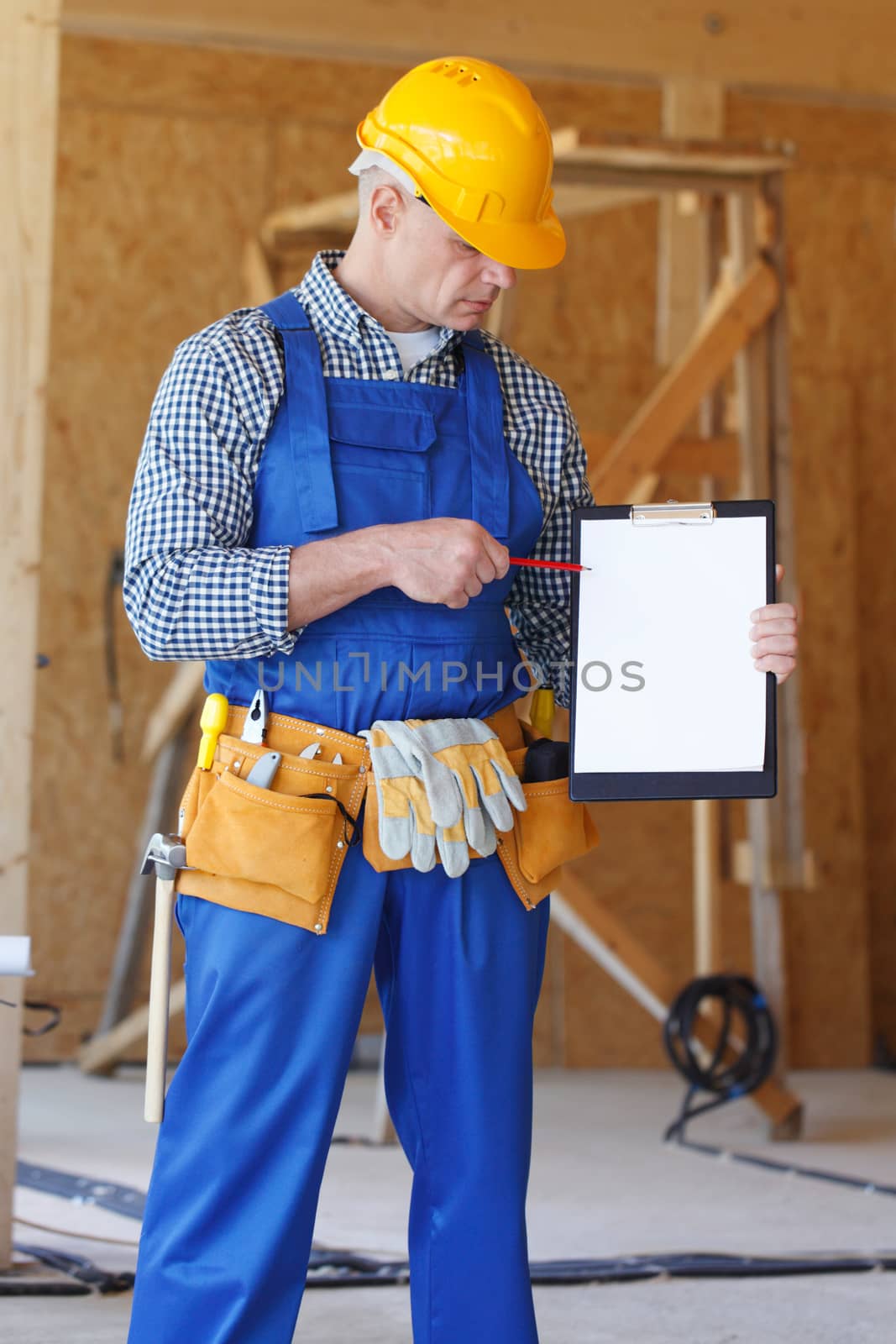 Portrait of foreman pointing at white folder plate