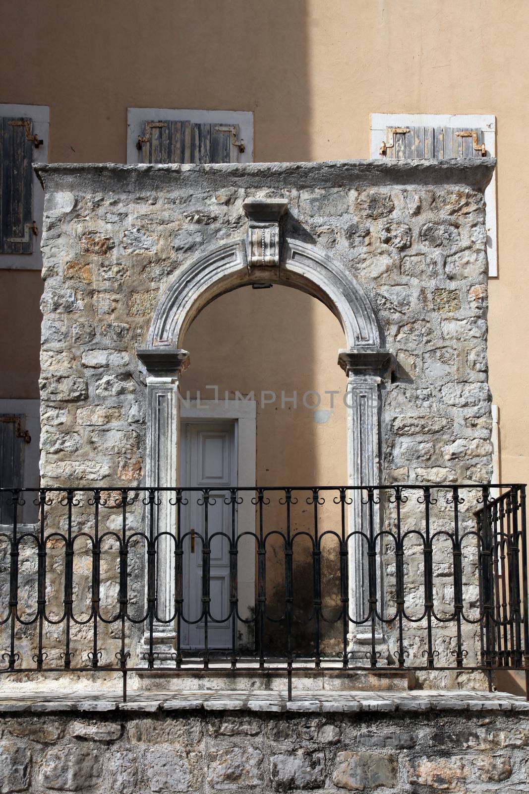 Old house, windows with shutters and stone arc in Budva, Montenegro
