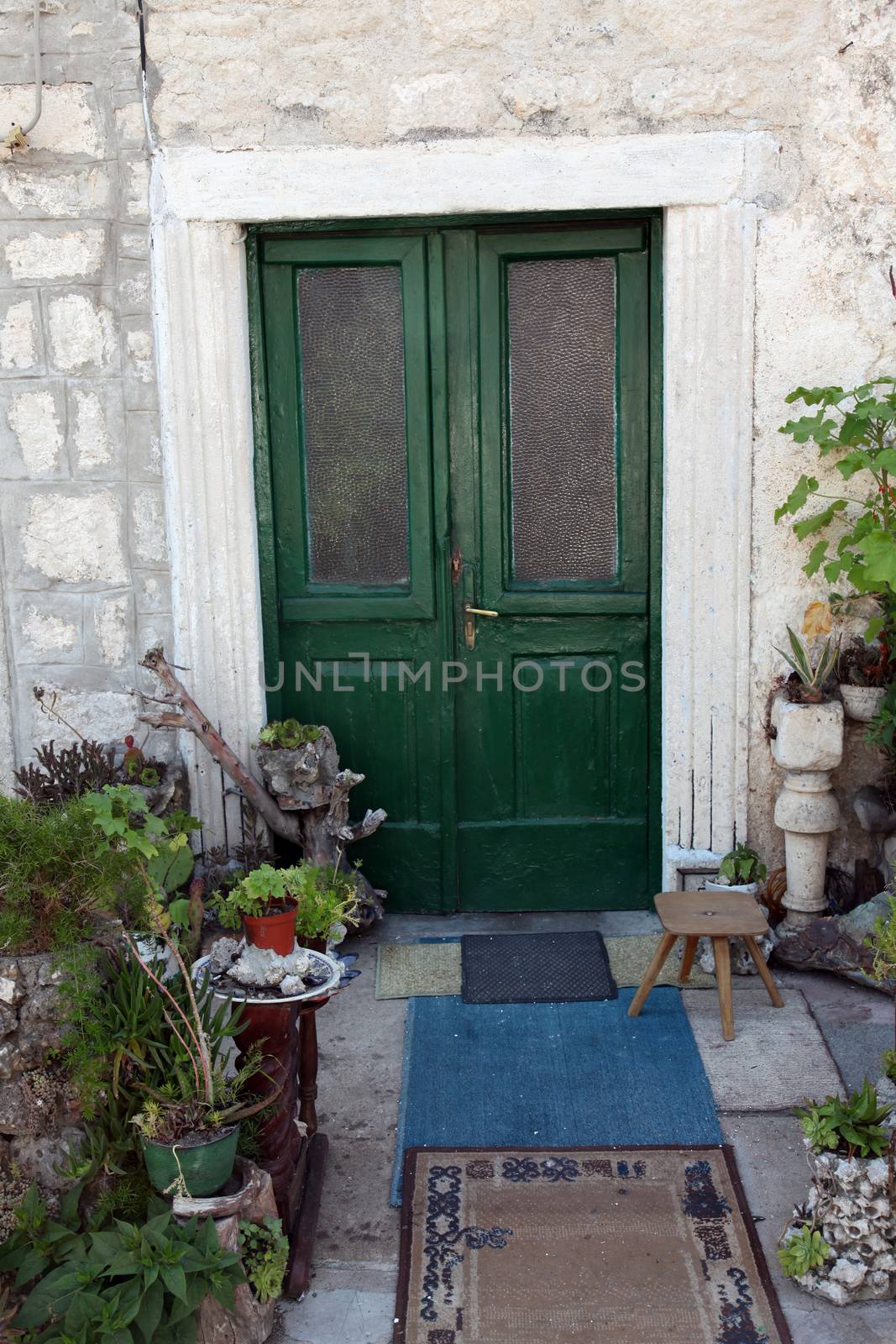 Mediterranean house with green door and flowers in Prcanj, Montenegro