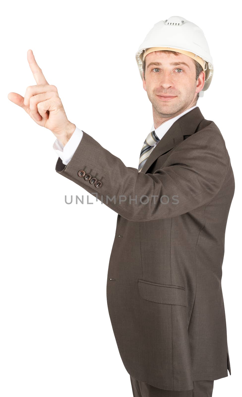 Businessman in helmet pointing at left corner and looking at camera isolated on white background