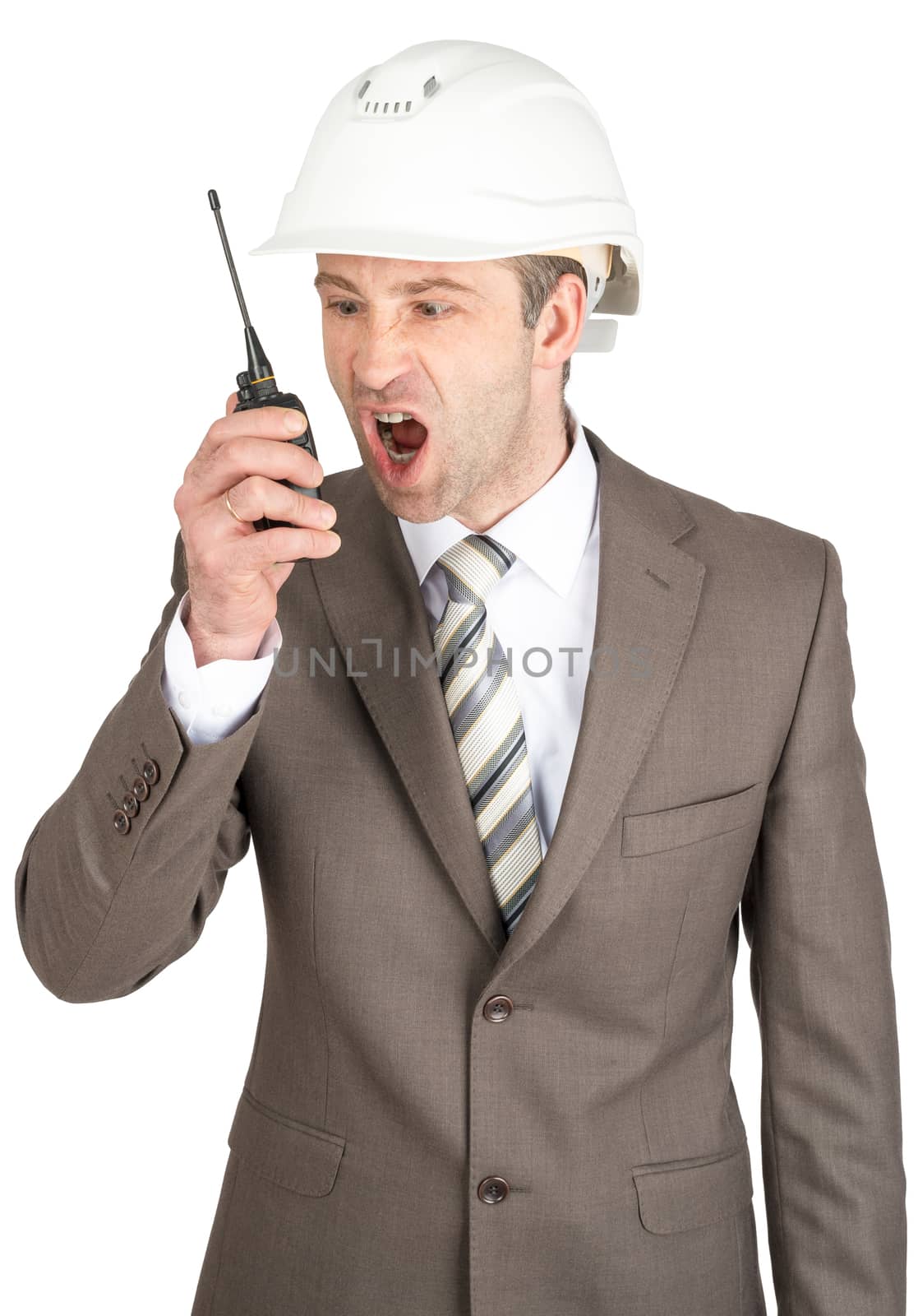 Angry businessman in helmet shouting at radio set isolated on white background
