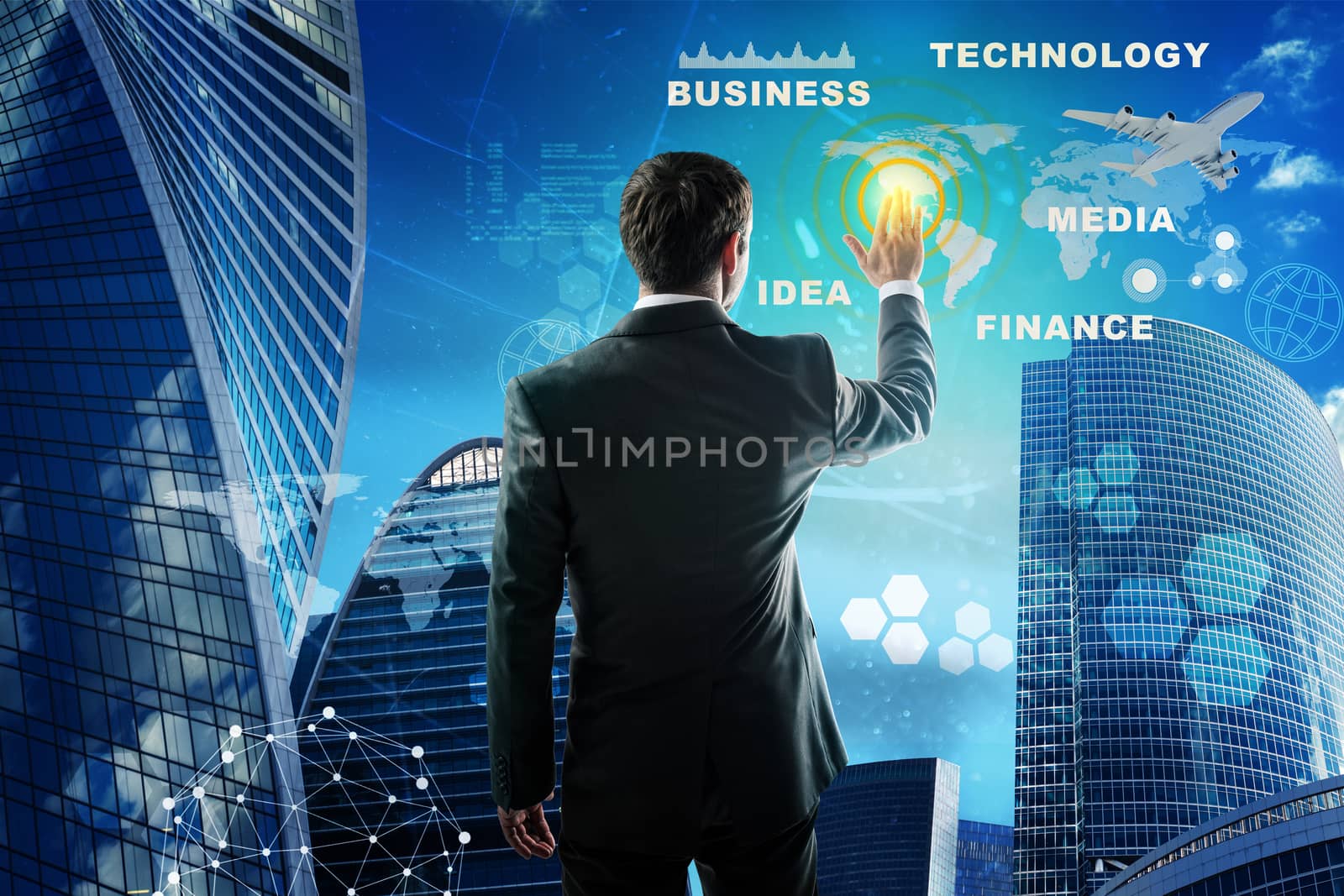 Businessman in suit working with digital vurtual screen. Skyscrapers as backdrop