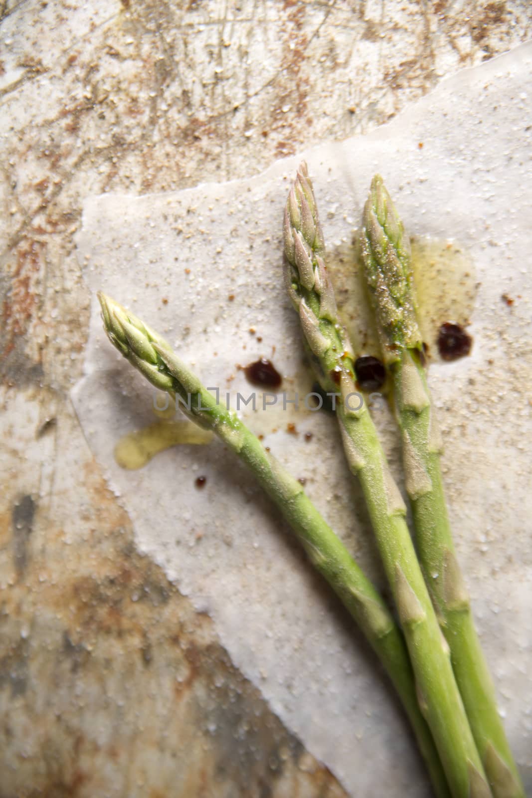 Presentation of some raw asparagus on metal background