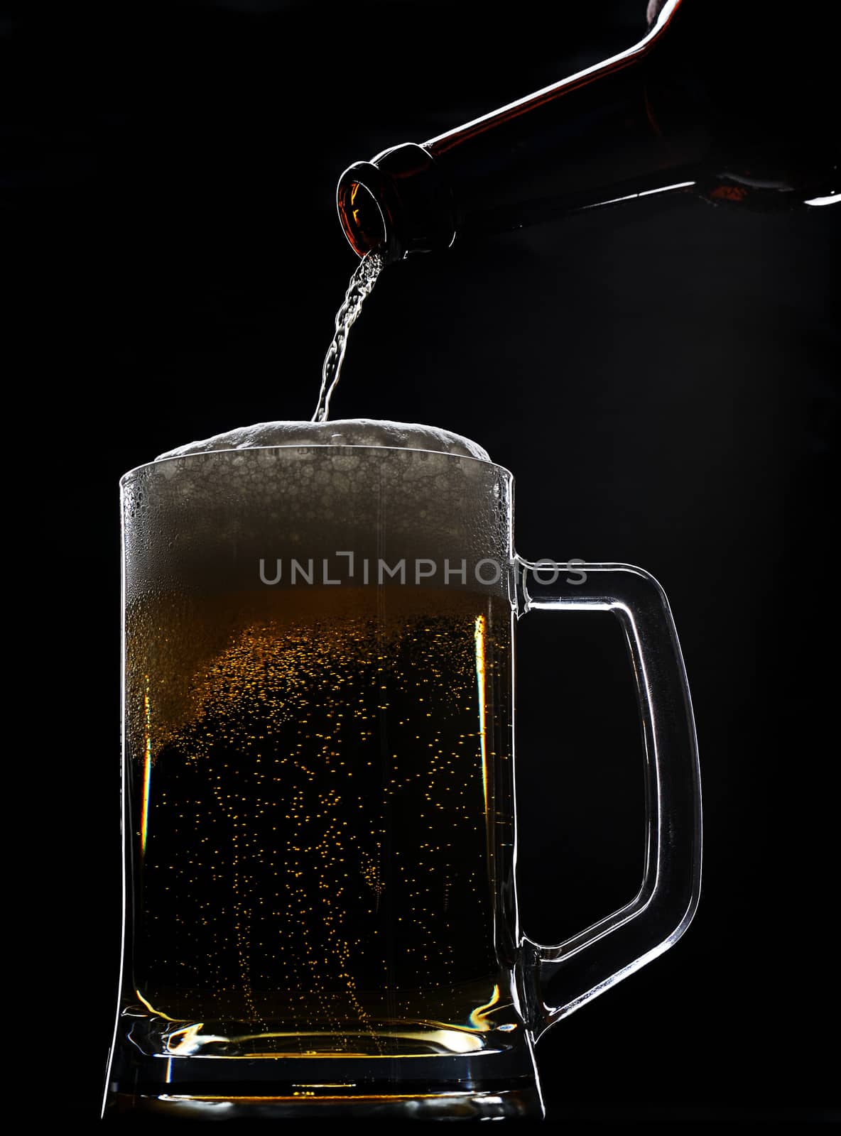 glass full beer and bottle on black background