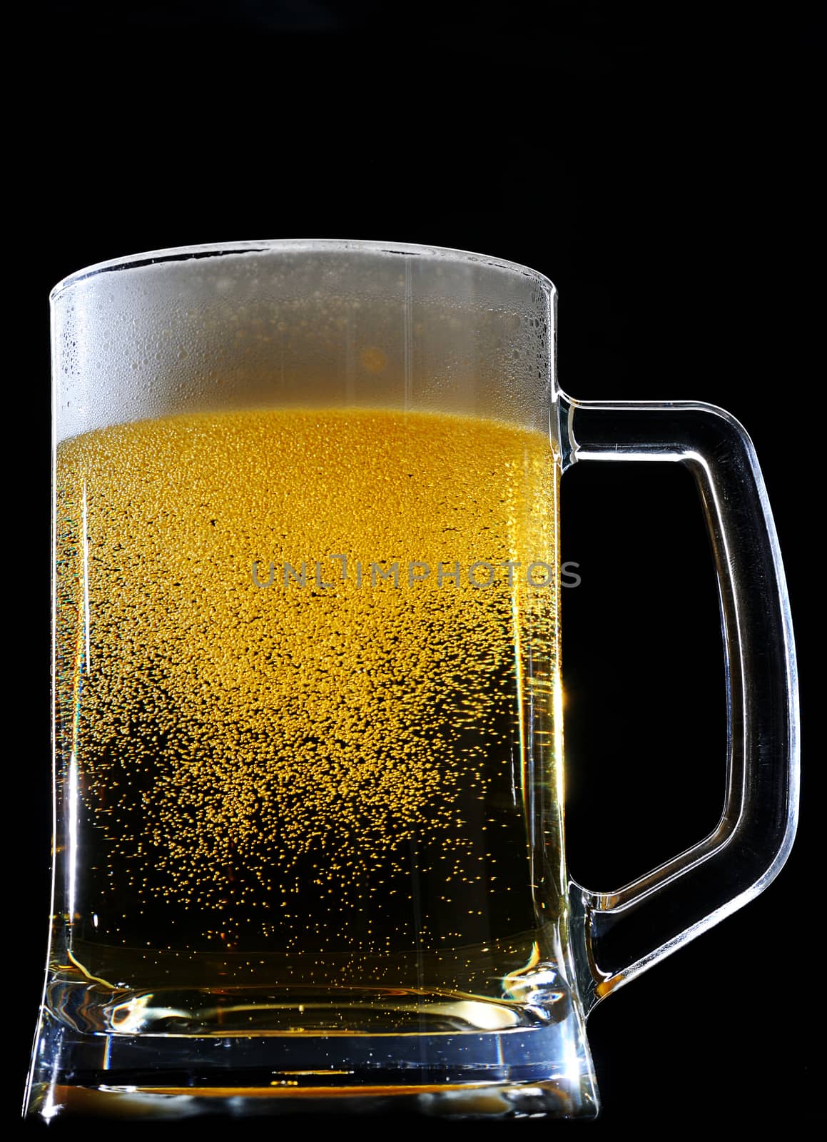 Fresh beer in glass with foam in sparkles