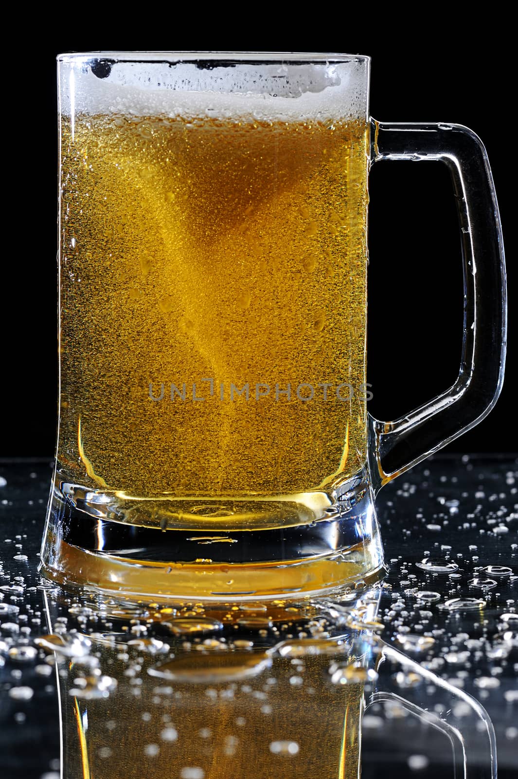 Sparkle beer on glass with wet drops on table