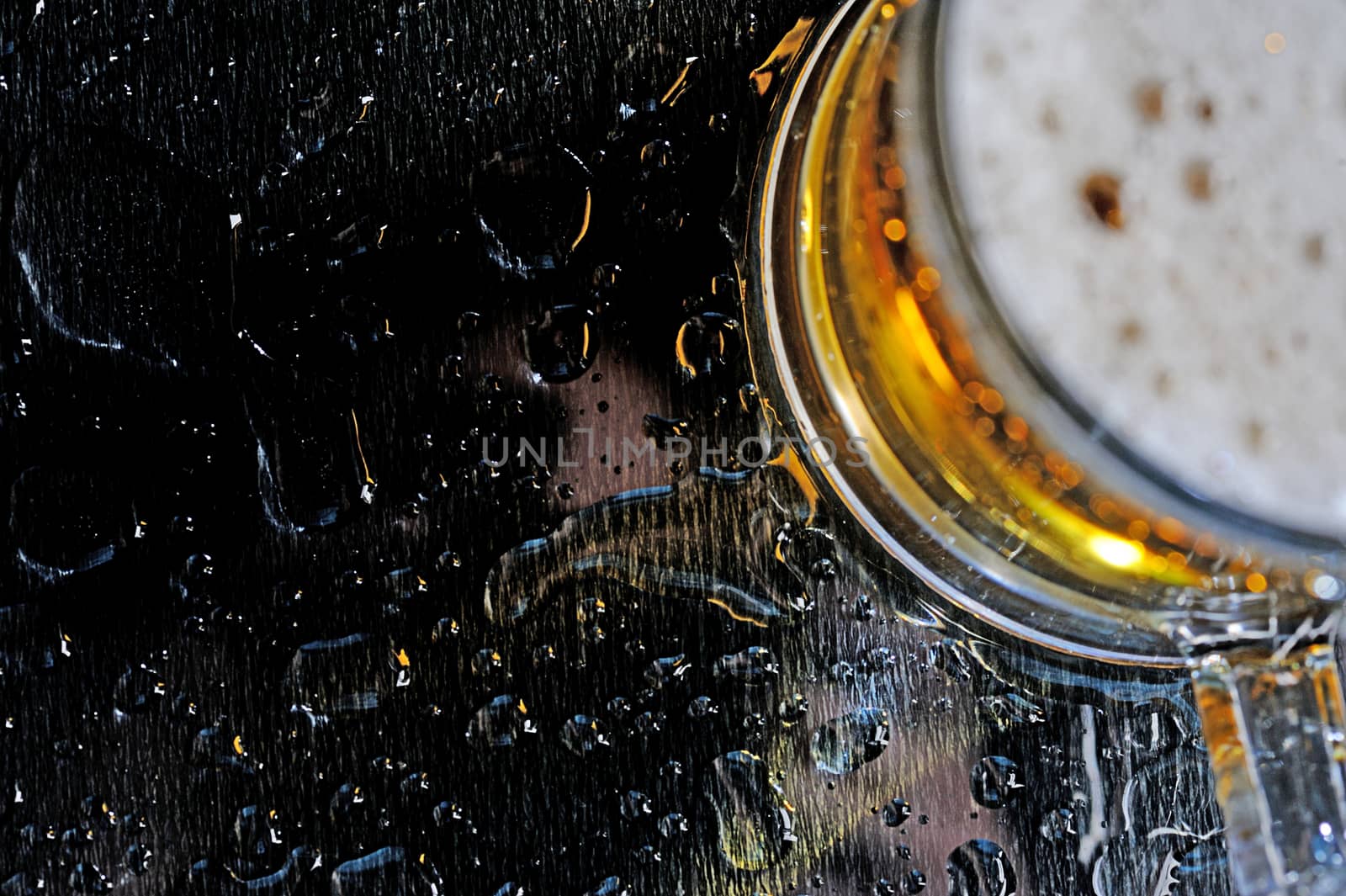 Black wet table with drops of brown beer