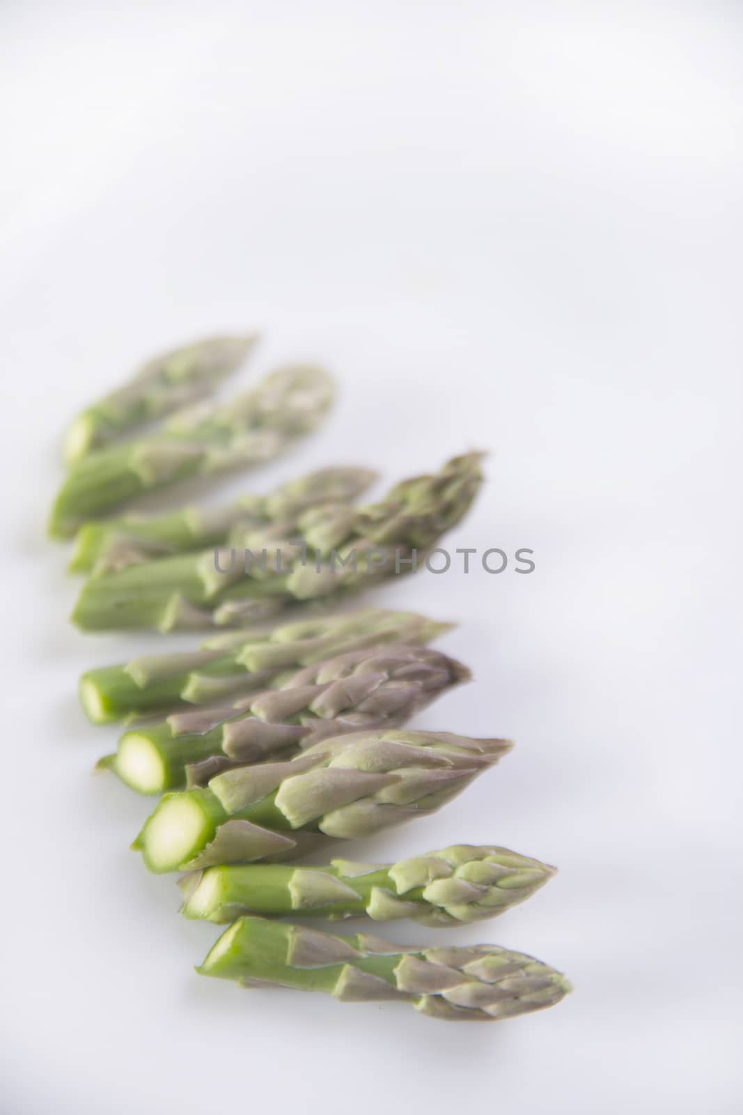 Presentation of raw asparagus spears on a white background