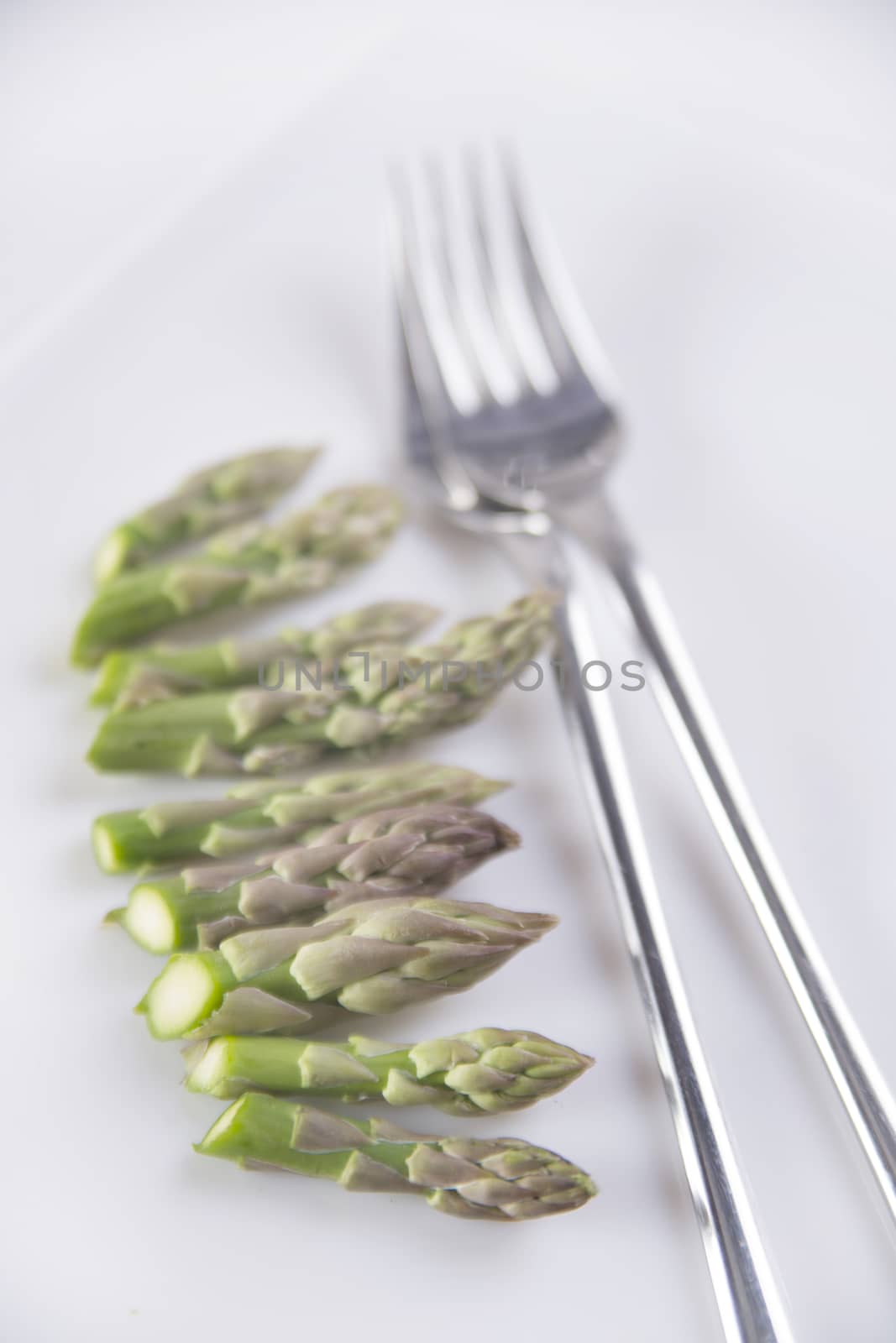 Presentation of raw asparagus spears on a white background