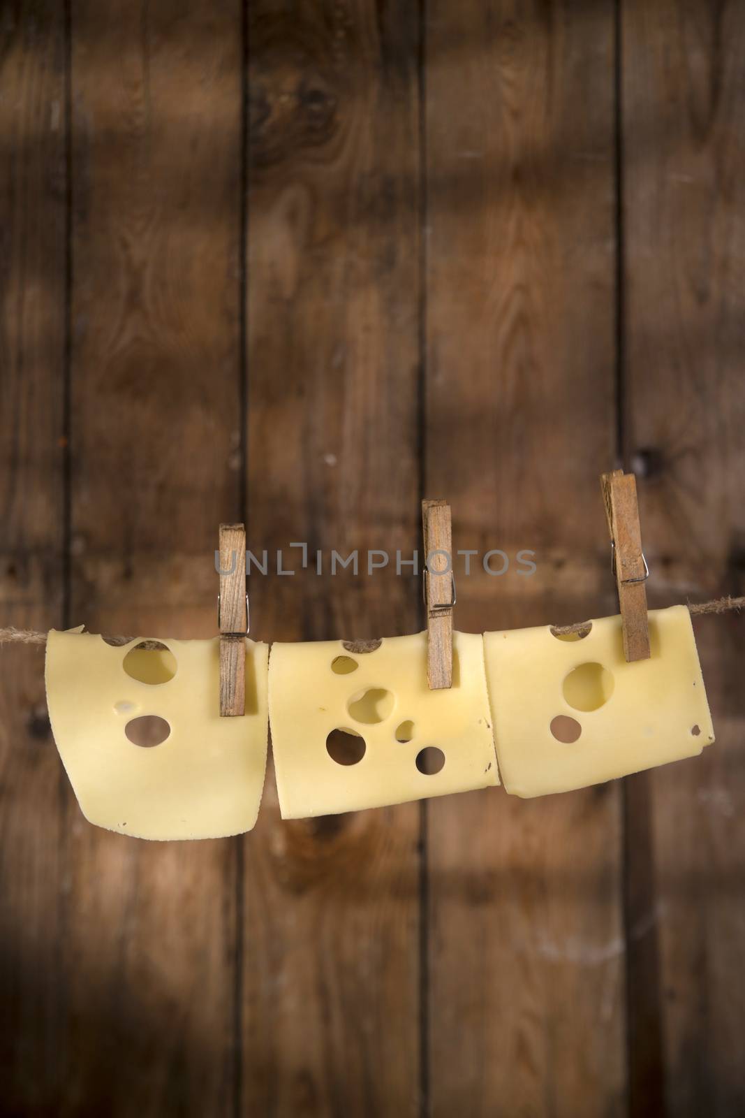 Presentation of slices of Swiss cheese Emmentaler hanging by a thread