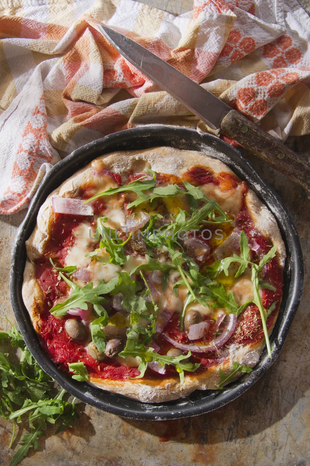 Pizza base with whole wheat flour with arugula and onion 

