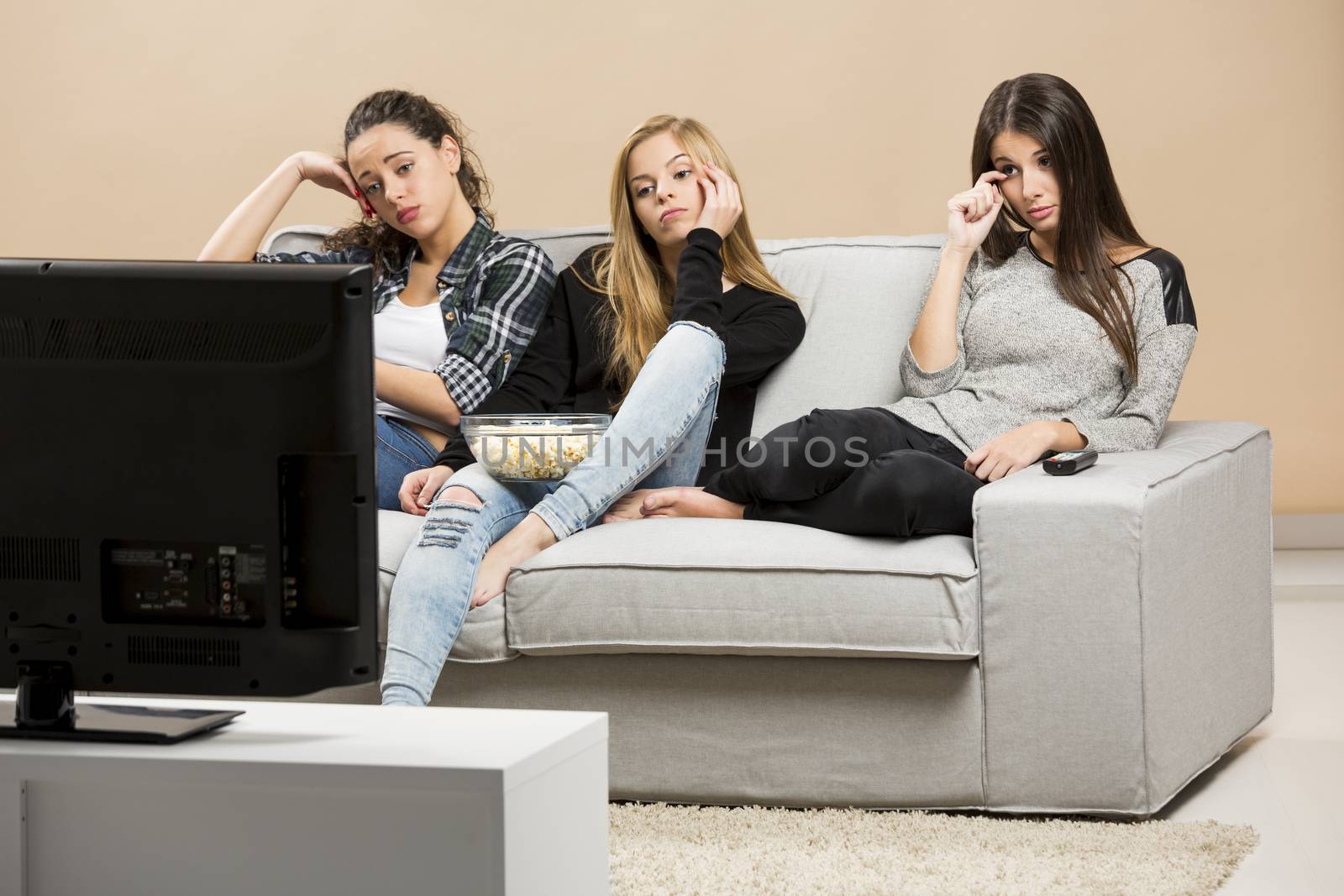 Teenage girls watching sad movies at home