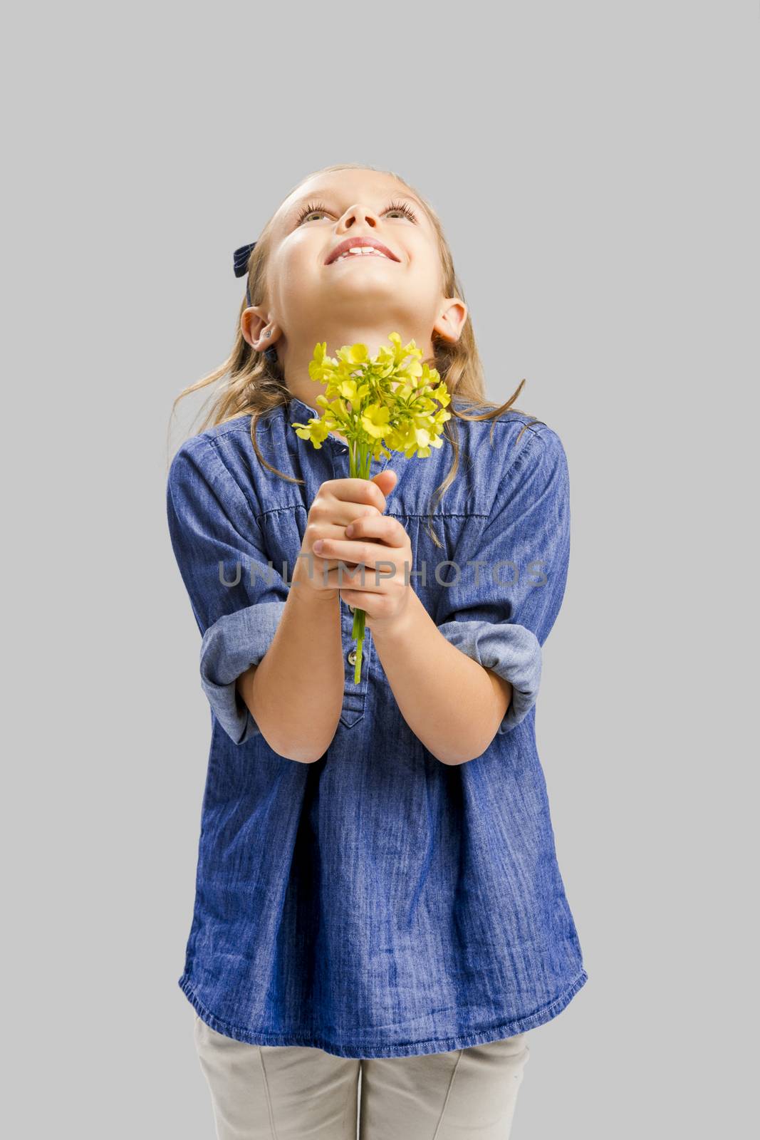 Studio portrait of a beautiful cute girl holding wild flowers