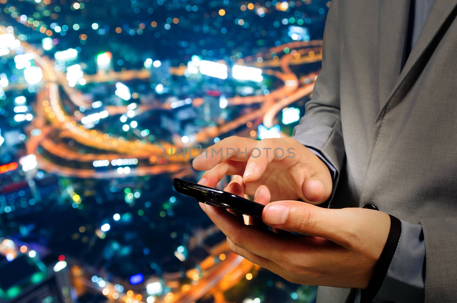 Handsome Business male in the city using his smartphone with Bokeh Background