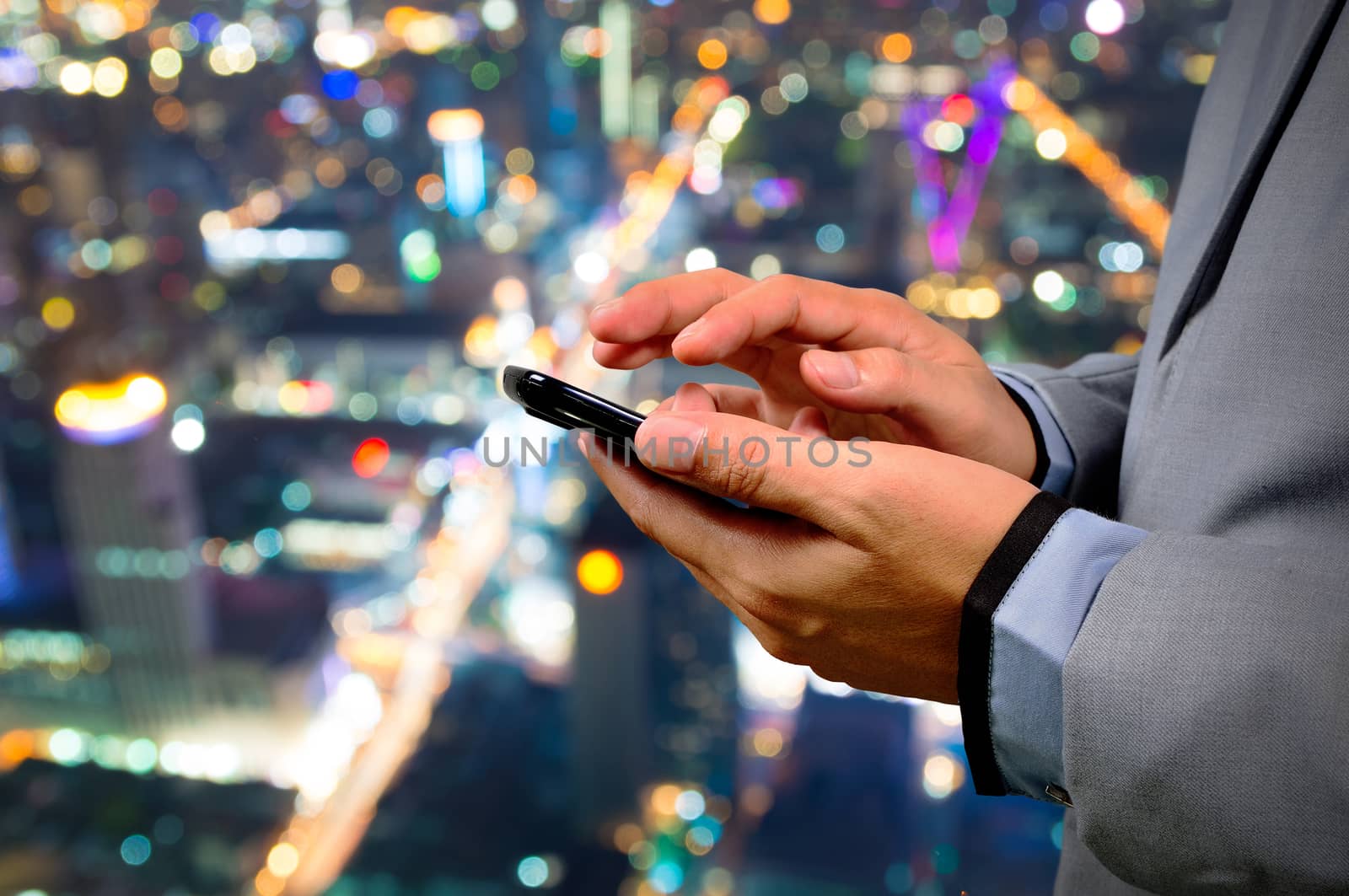 Handsome Business male in the city using his smartphone with Bokeh Background