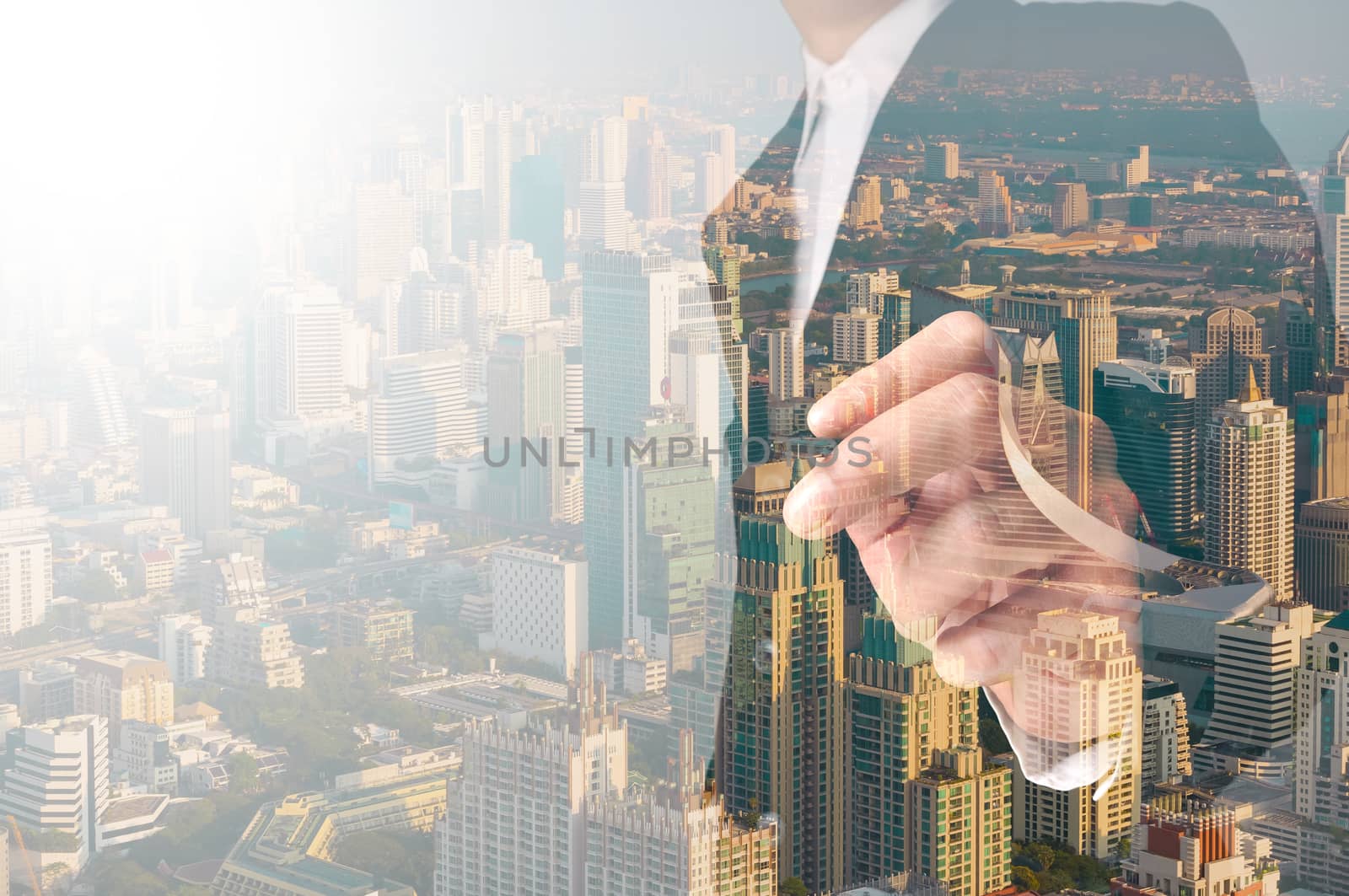 businessman writing something on transparent board with city reflection, double exposure