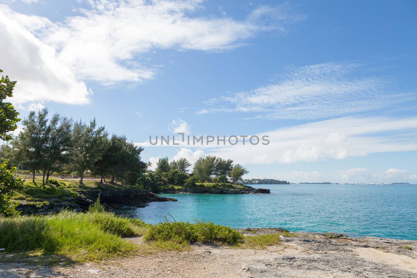 Bermuda coast with aqua blue tropical waters and rock formations complete with small caves.