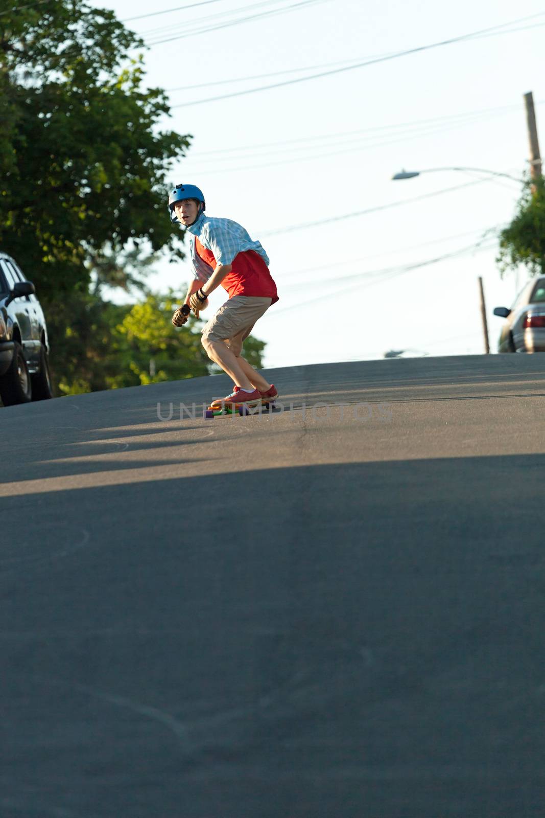 Action shot of a longboarder skating on a suburban road.