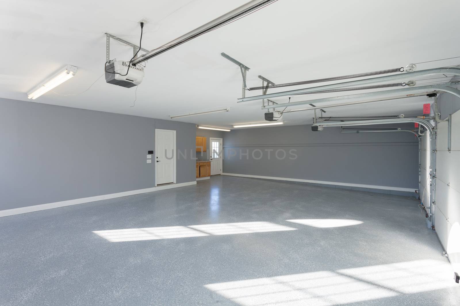 Beautiful brand new three car garage interior with finished floors and work space.