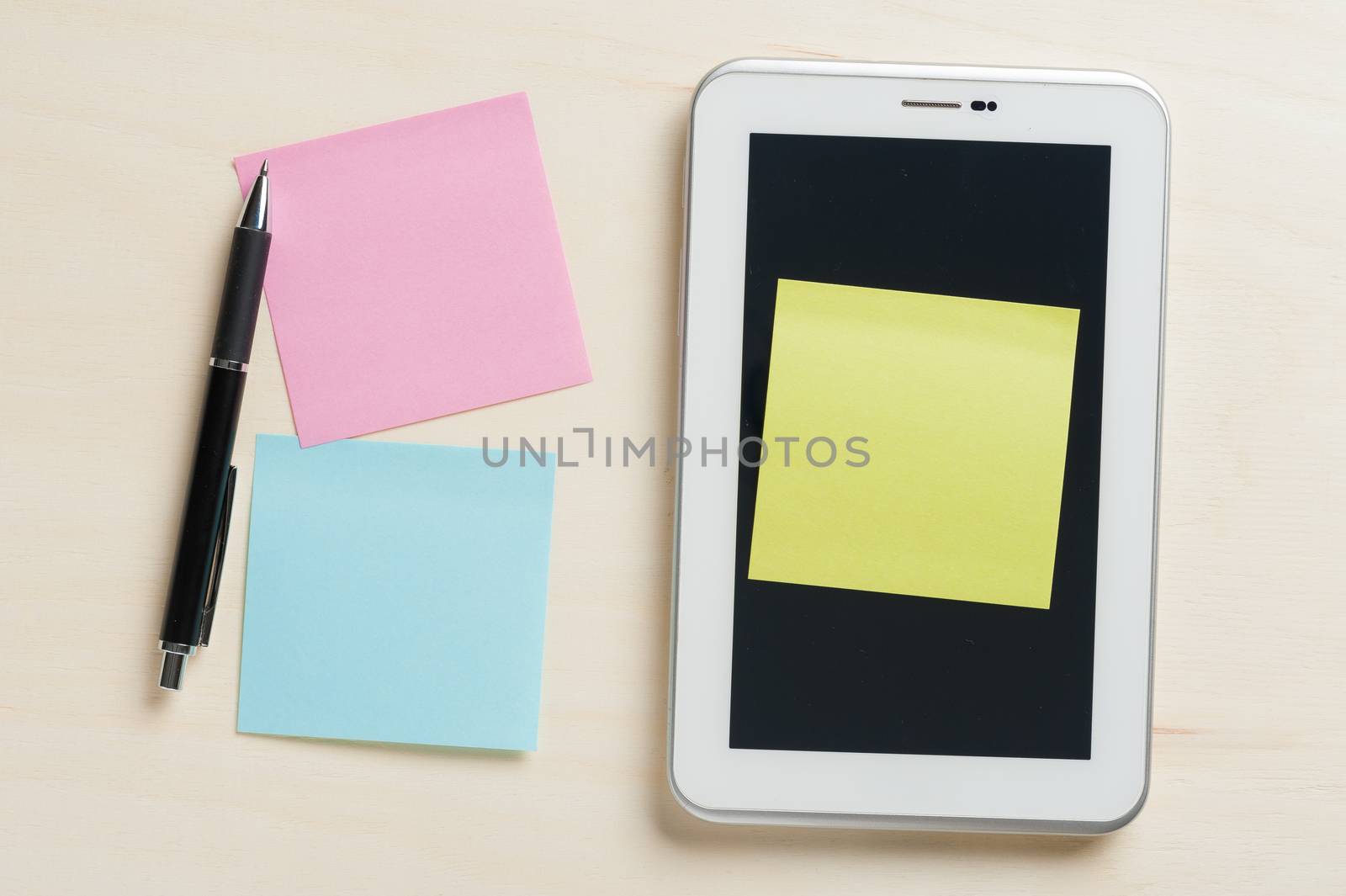 Yellow sticky paper with blank copy space stick on small tablet pc on wood table