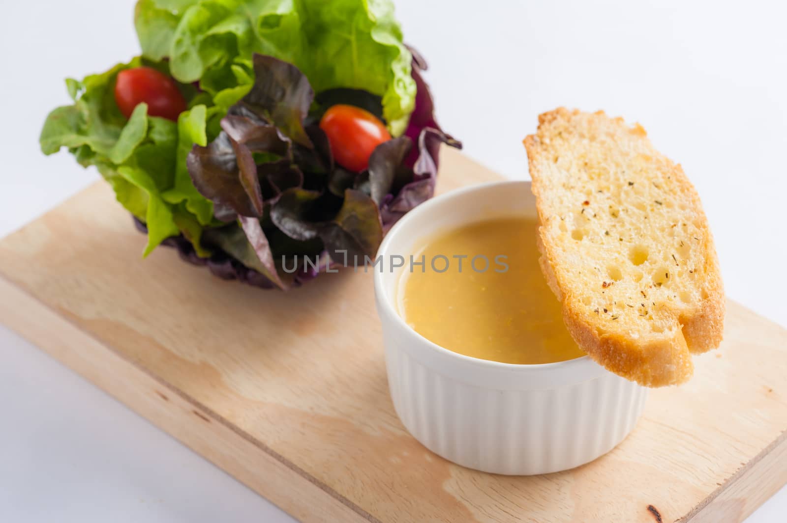 Corn soup in ceramic cup with toast and freash vegetables on wood plate. Clean and healthy eating concept food.