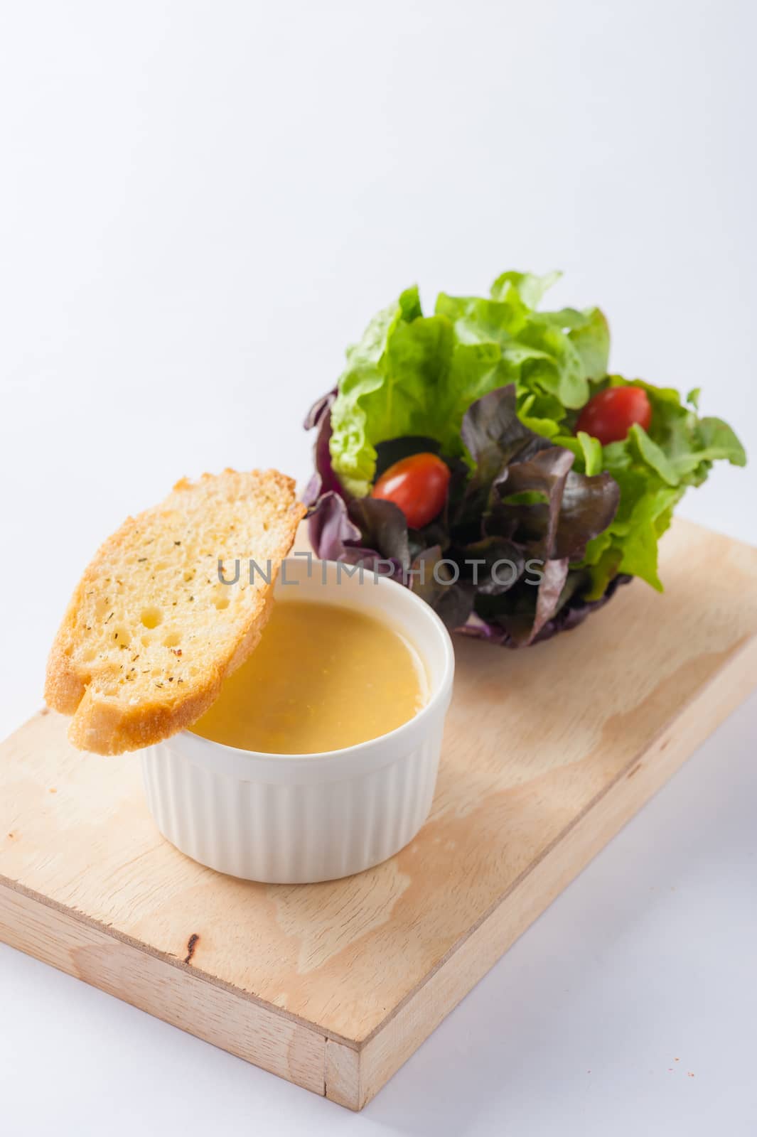 Corn soup in ceramic cup with toast and freash vegetables on wood plate. Clean and healthy eating concept food.