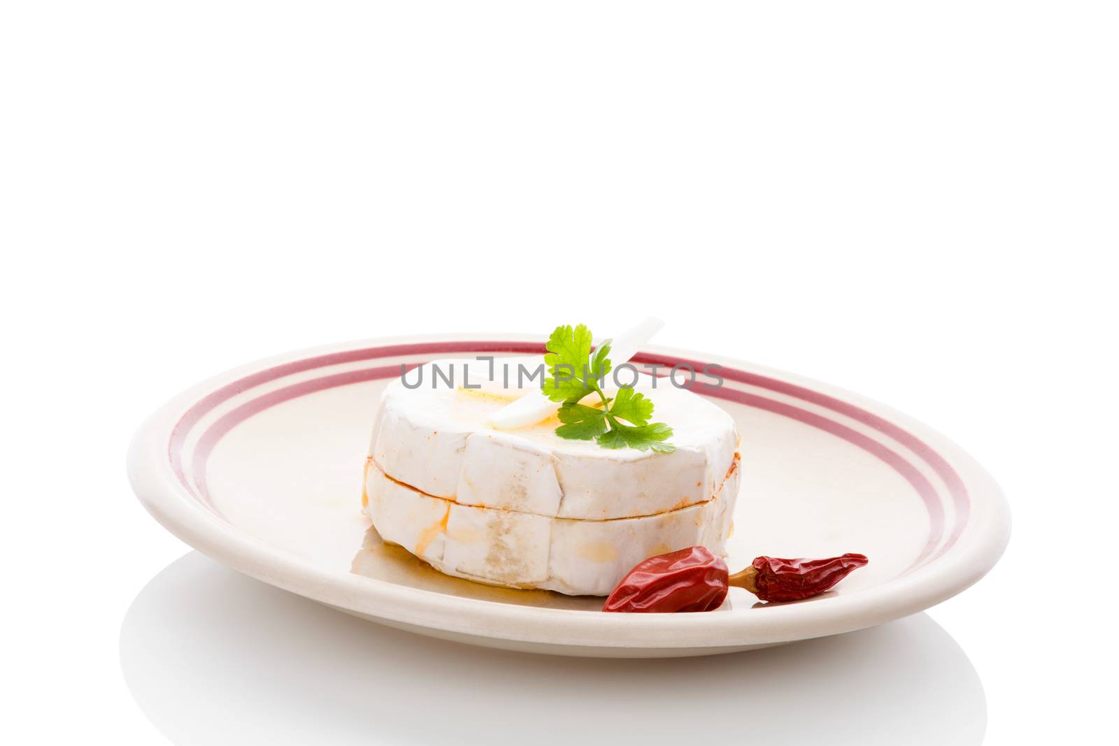 Delicious marinated camembert cheese on plate isolated on white background. Traditional czech cheese eating.