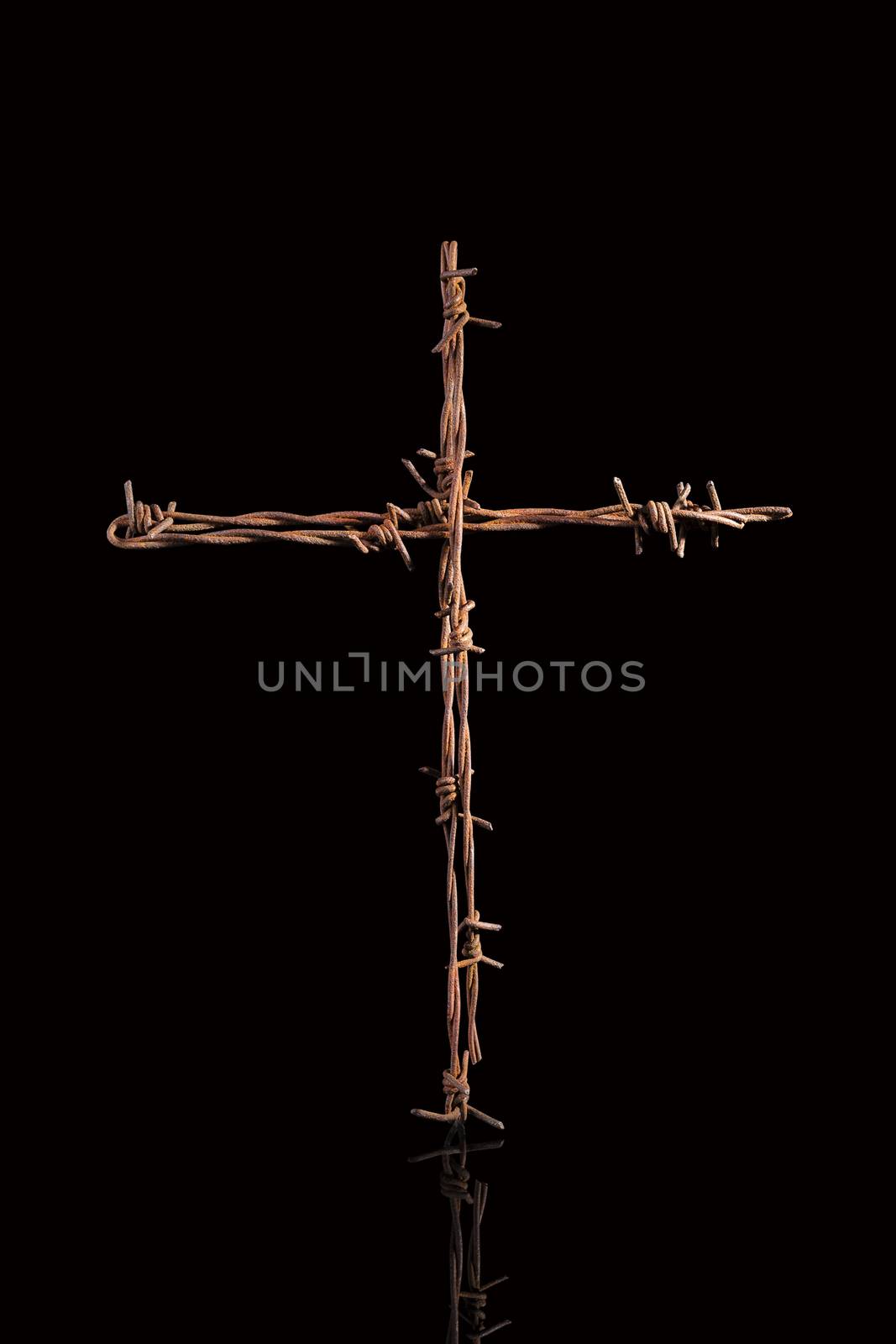 Rusty barbwire cross isolated on black background. Religious war.