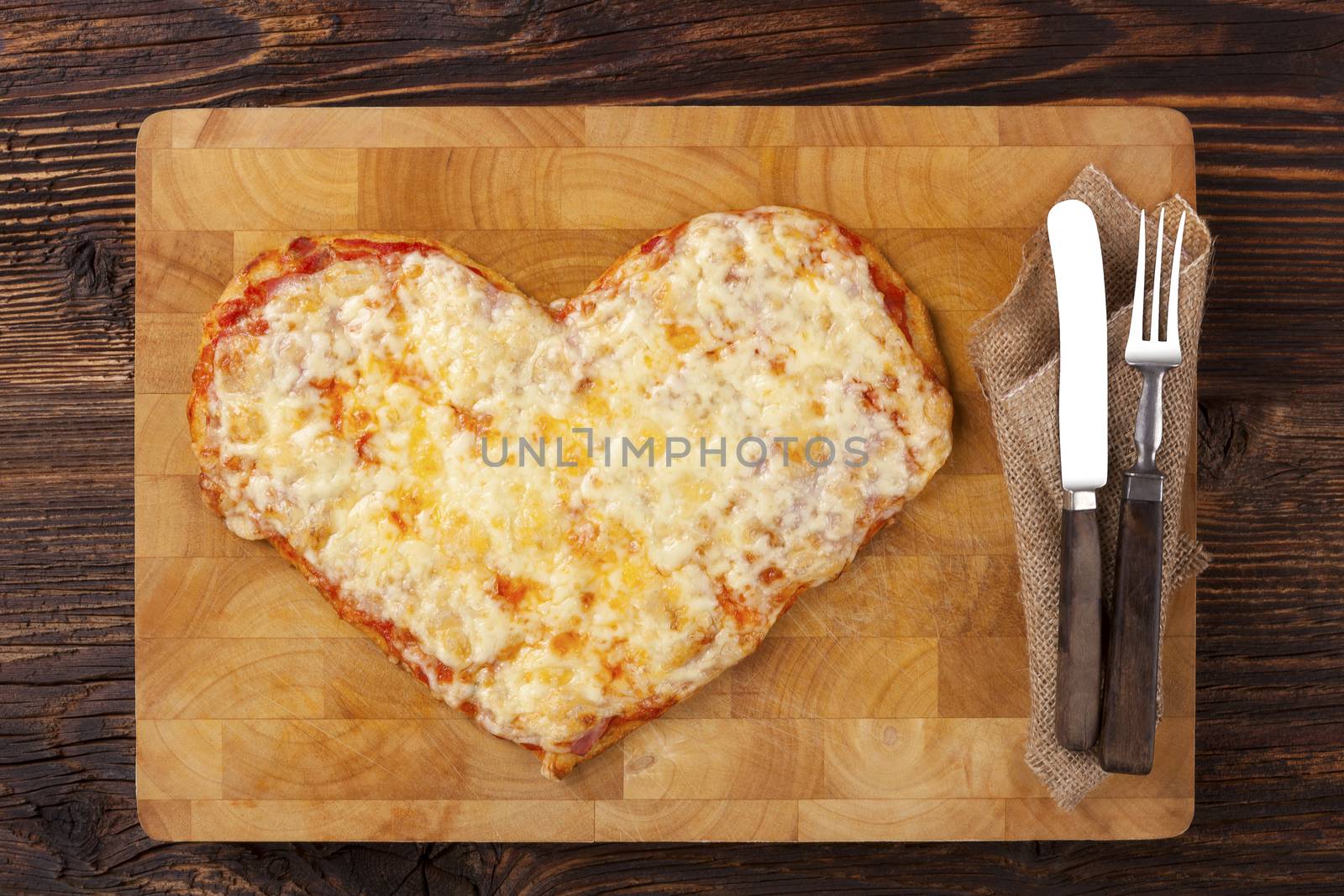 Culinary pizza eating. Pizza in heart shape on wooden table, top view. Culinary pizza eating. I love pizza.