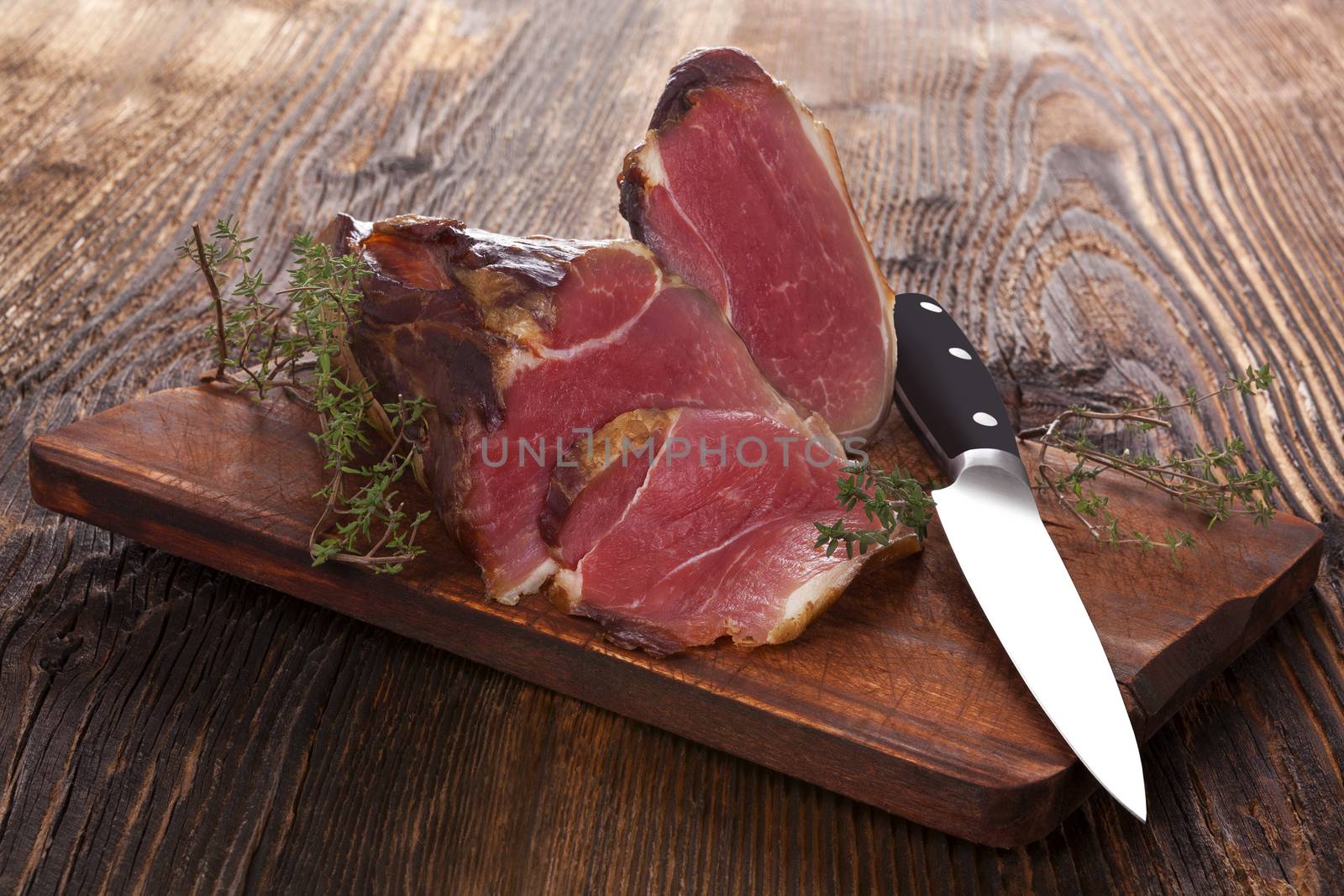 Traditional smoked meat on wooden table. Culinary meat eating. 