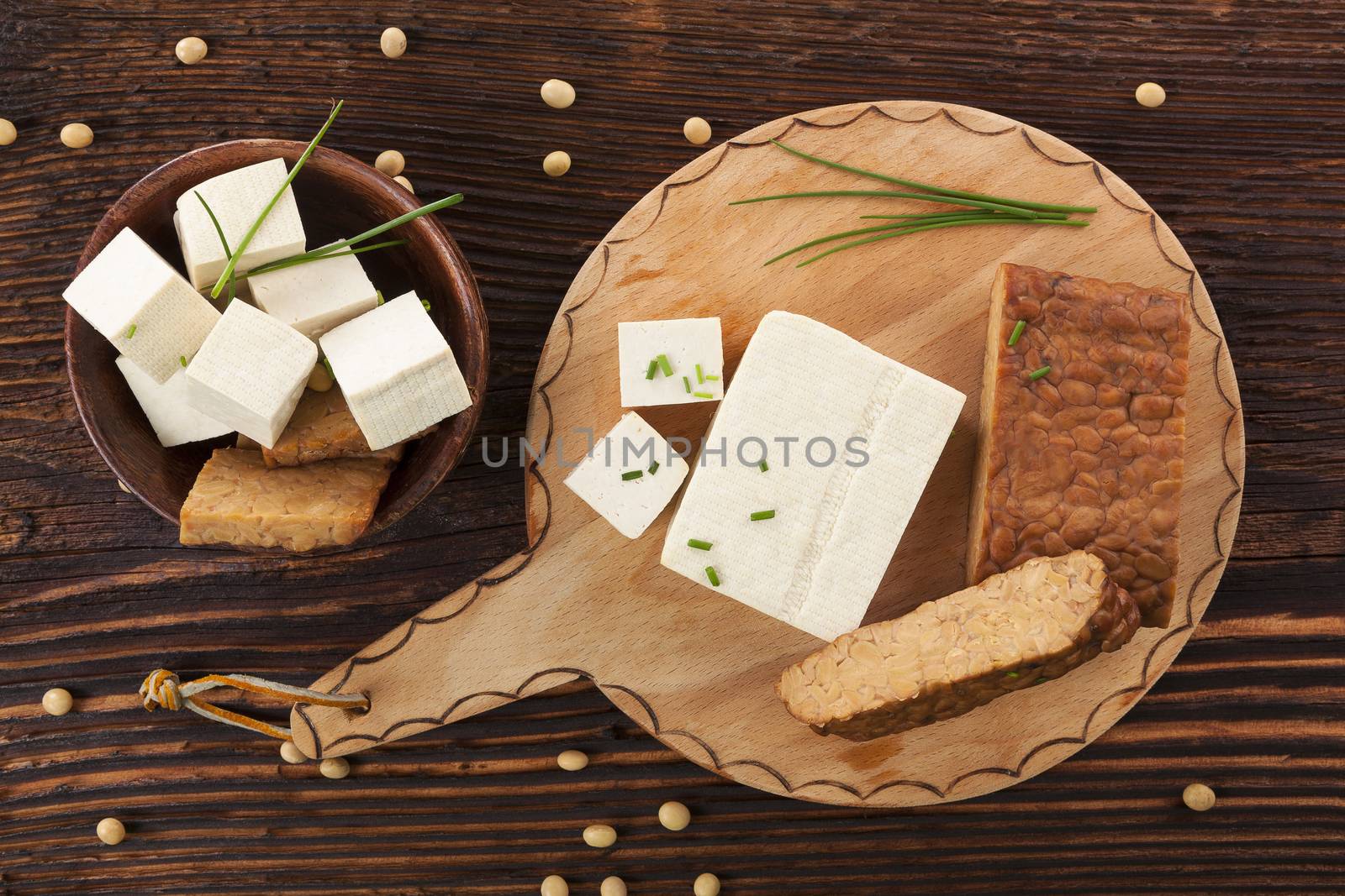 Tofu and tempeh background on brown wooden background. Culinary vegan eating. 
